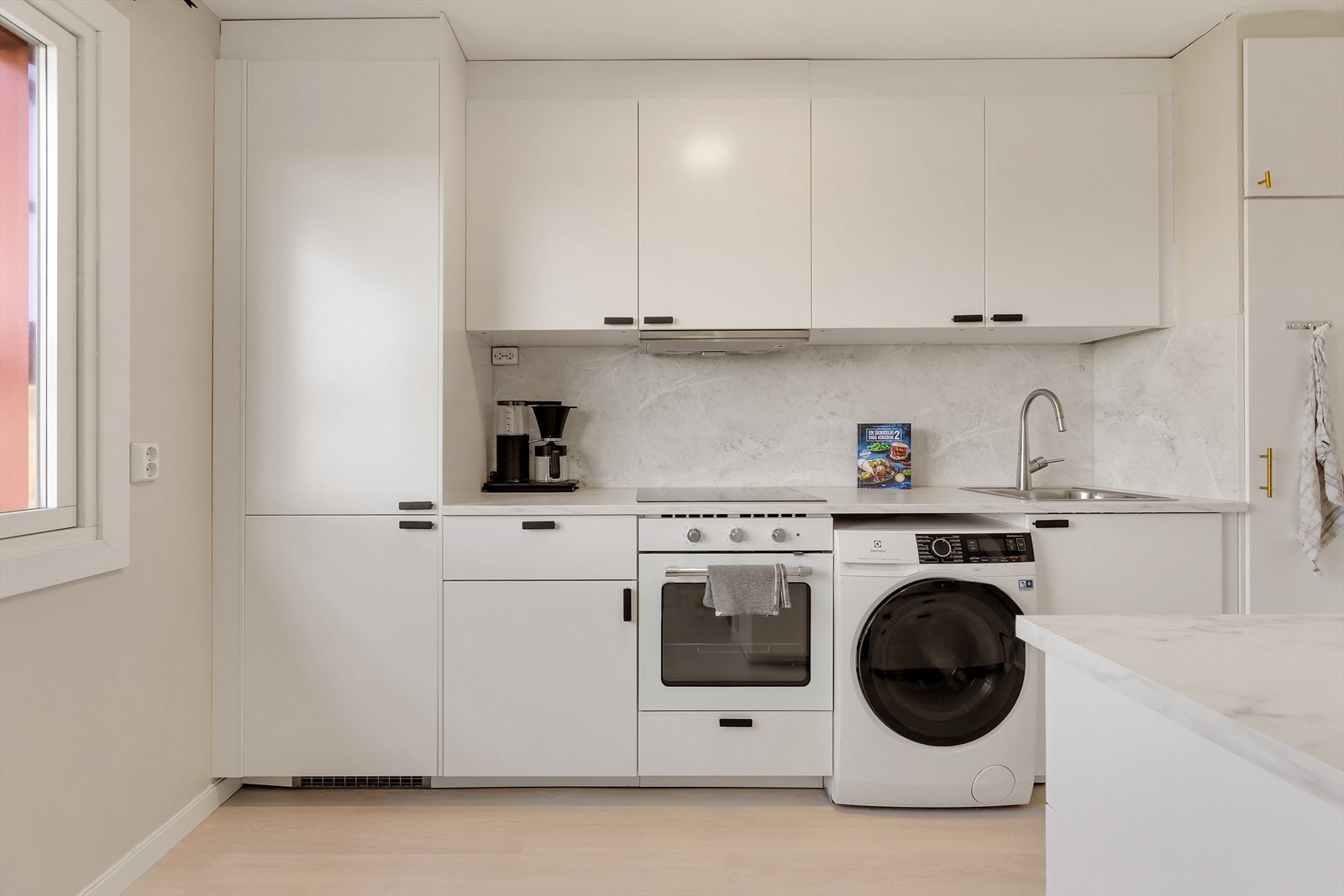 Lekker og moderne IKEA kjøkkeninnredning fra 2022 med slette fronter, overskap toppforet til himling, laminat benkeplate med nedfelt kum. Galleribilde