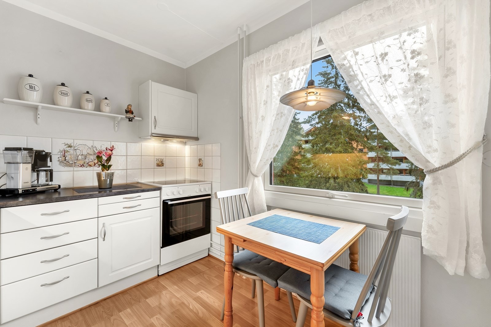 Kjøkkeninnredning med profilerte lakkerte fronter, laminat benkeplate med fliser over, oppvaskkum og ventilator. Komfyr og kjøl-/fryseskap medfølger. Galleribilde