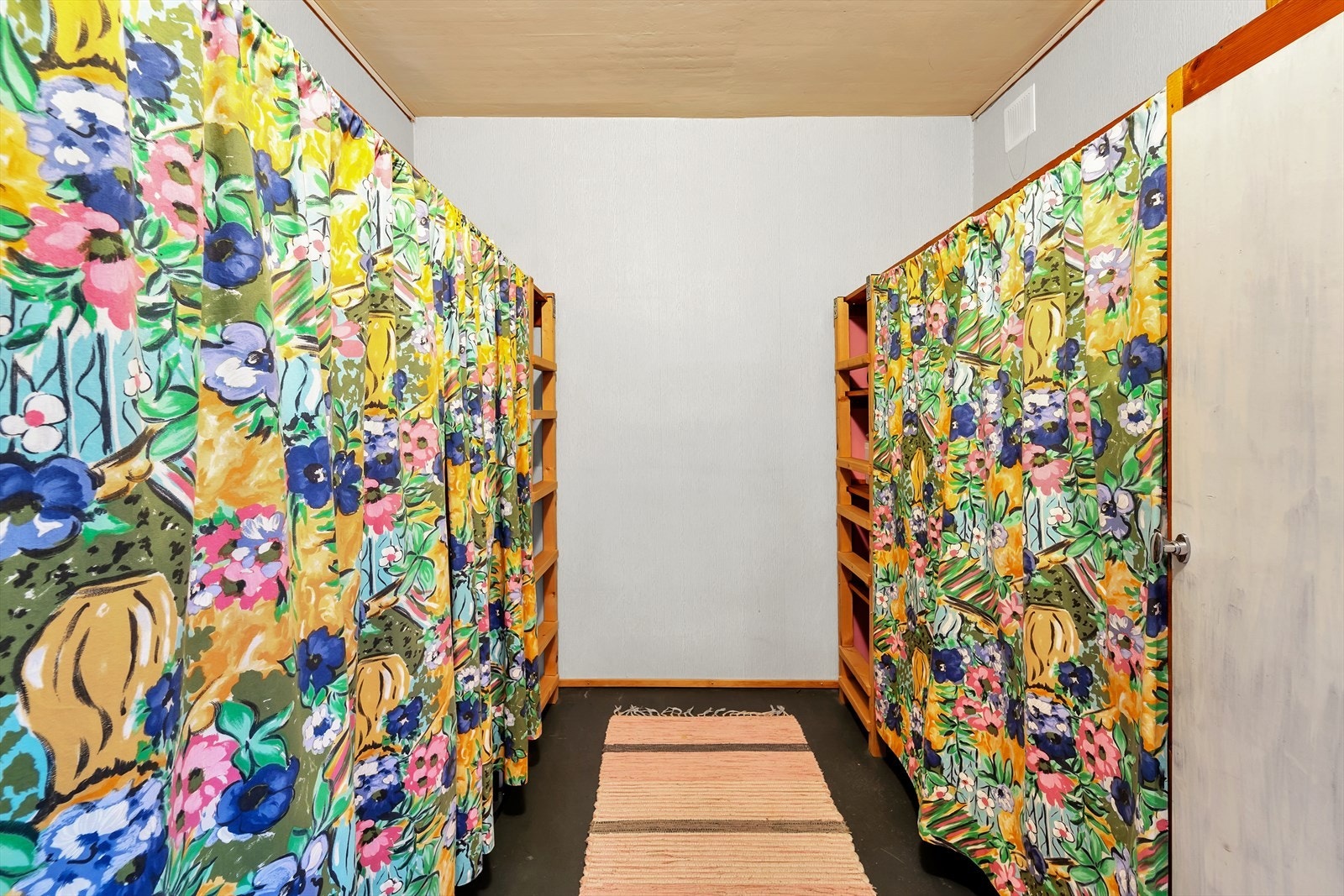 Garderobe/bod med belegg på gulv, malte vegger og malt tak. Det er montert hyller. Galleribilde