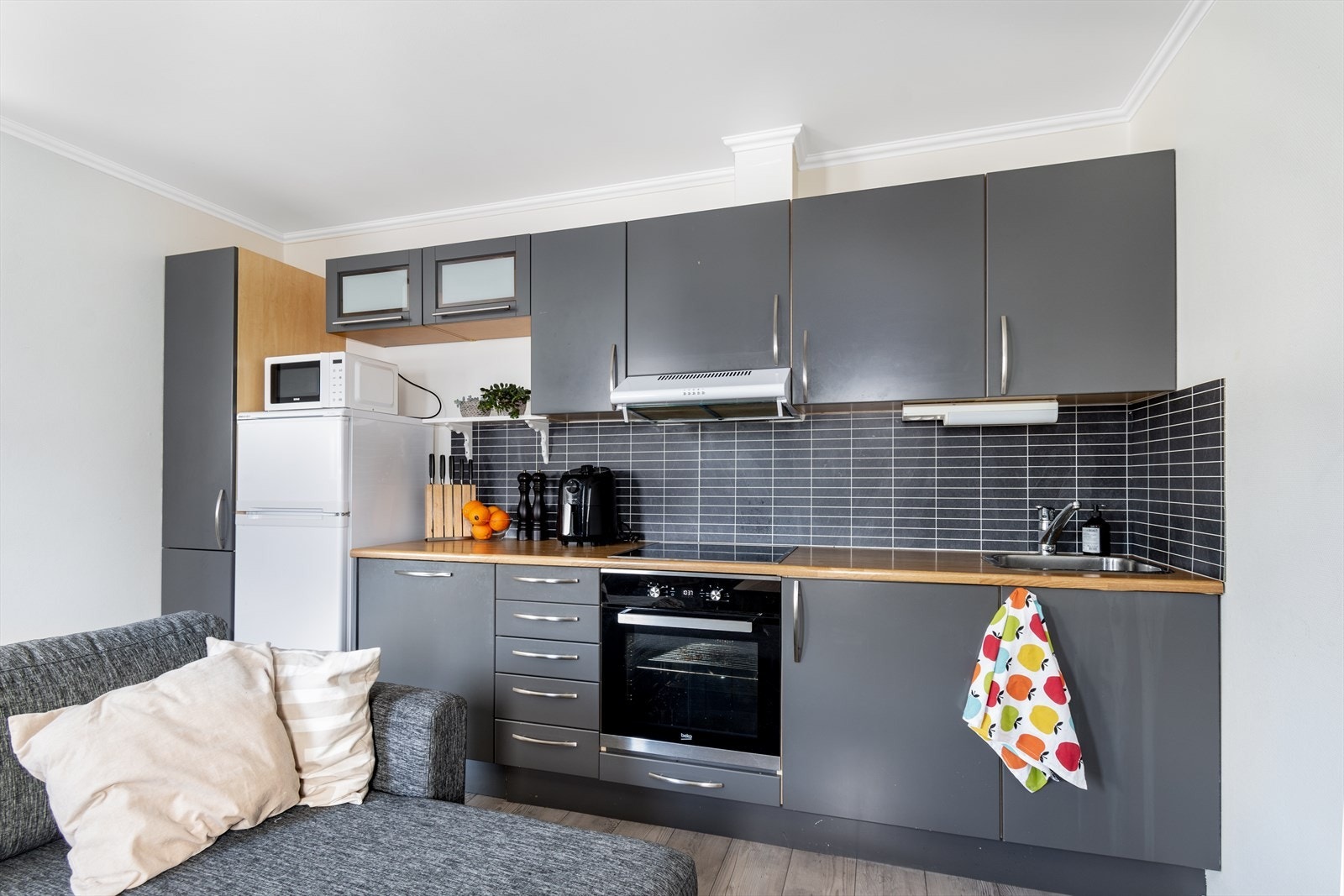 Delikat kjøkken med gjennomgående pen standard og integrerte hvitevarer som oppvaskmaskin, platetopp og stekeovn. Galleribilde