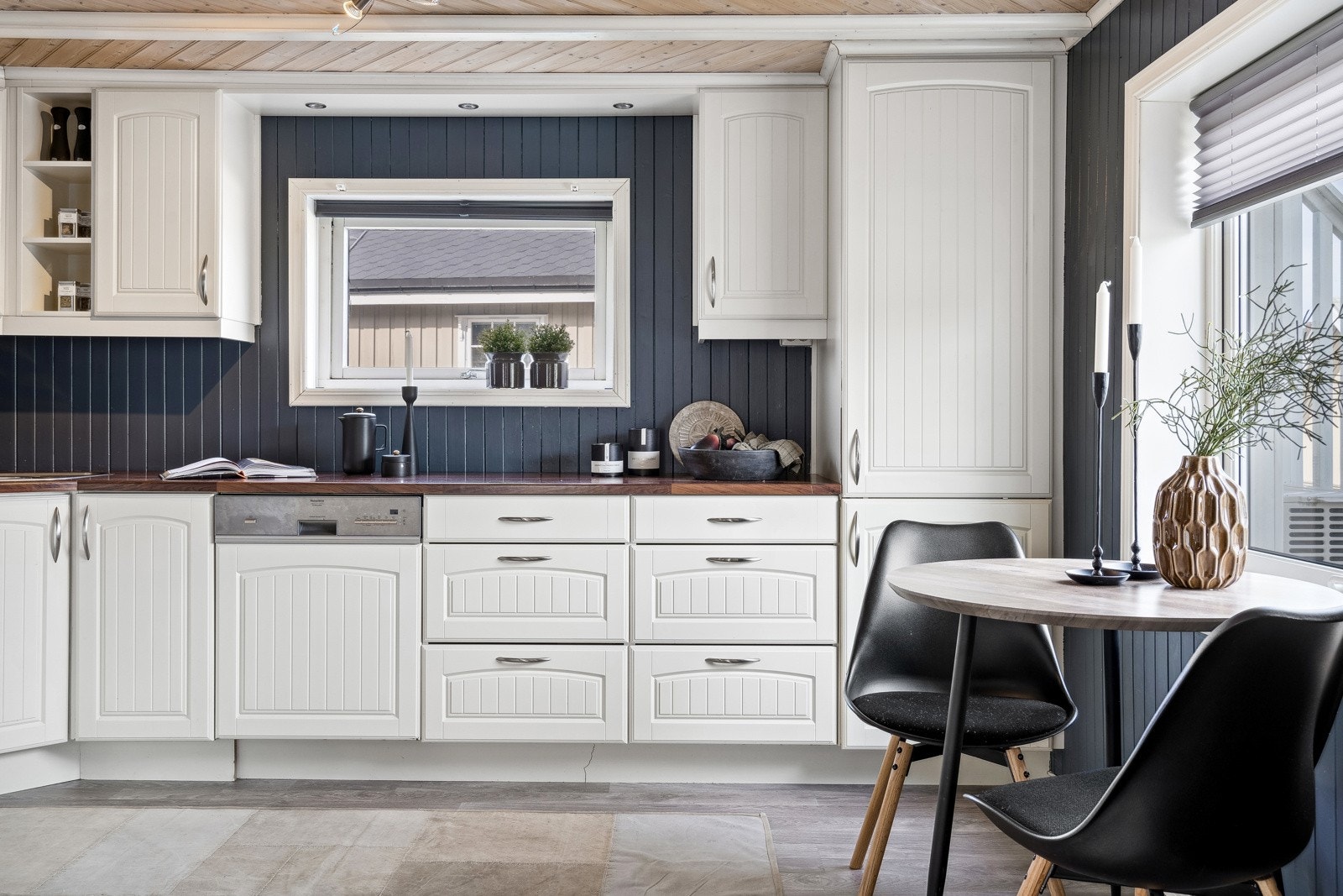 Lyst kjøkken med rikelig skap, skuff og benkeplass. Galleribilde