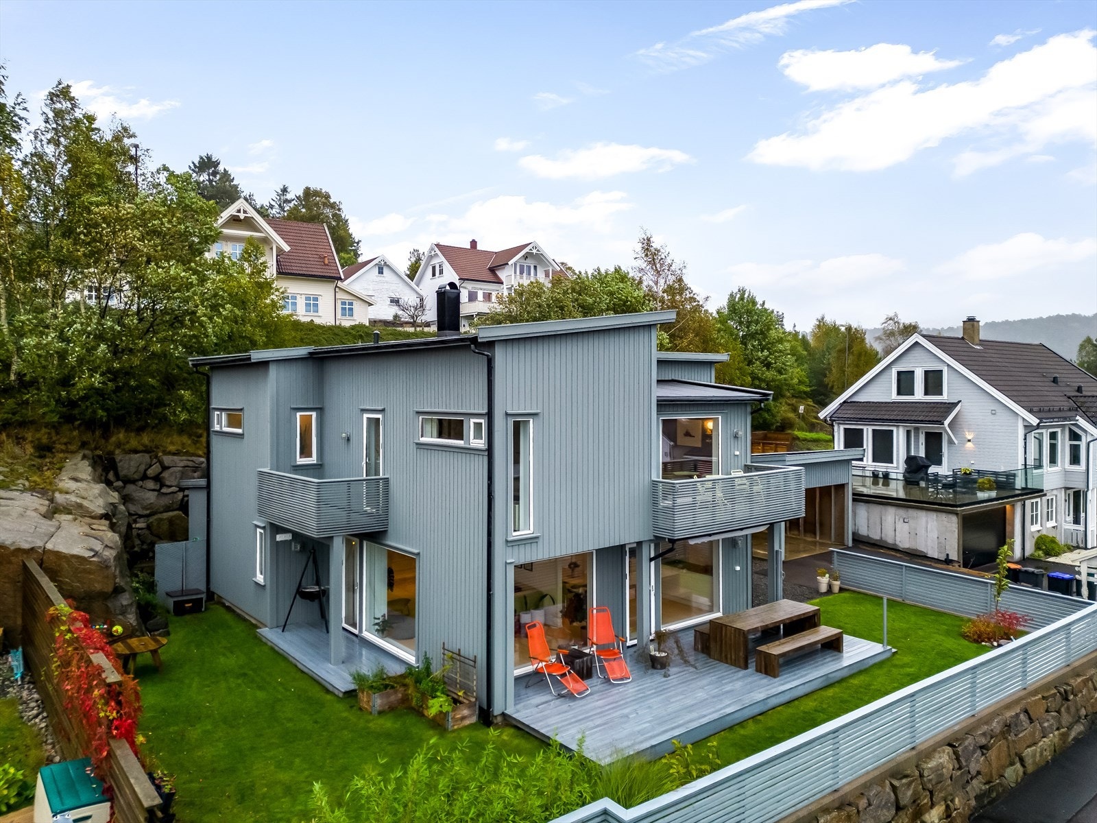 Pen og velstelt tomt som er opparbeidet med lettstelt plen, blomsterbed og flotte prydbusker. Galleribilde