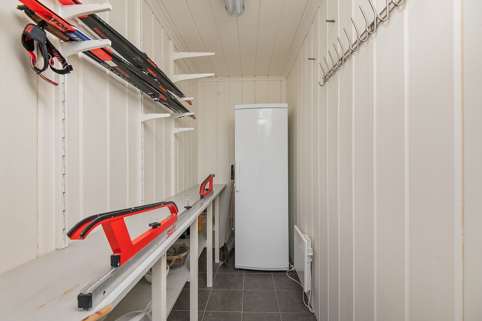 Utvendig, fullisolert bod med smørebenk og smart lagring for ski og utstyr. Selger har plassert et ekstra kjøleskap i boden. Galleribilde