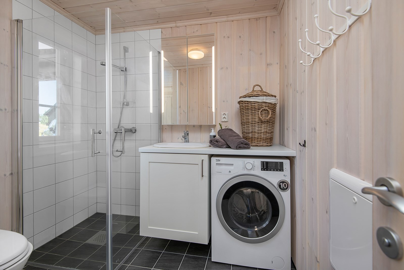 Praktisk bad/wc på hovedplan. Enkel servantinnredning med skap for oppbevaring. Galleribilde