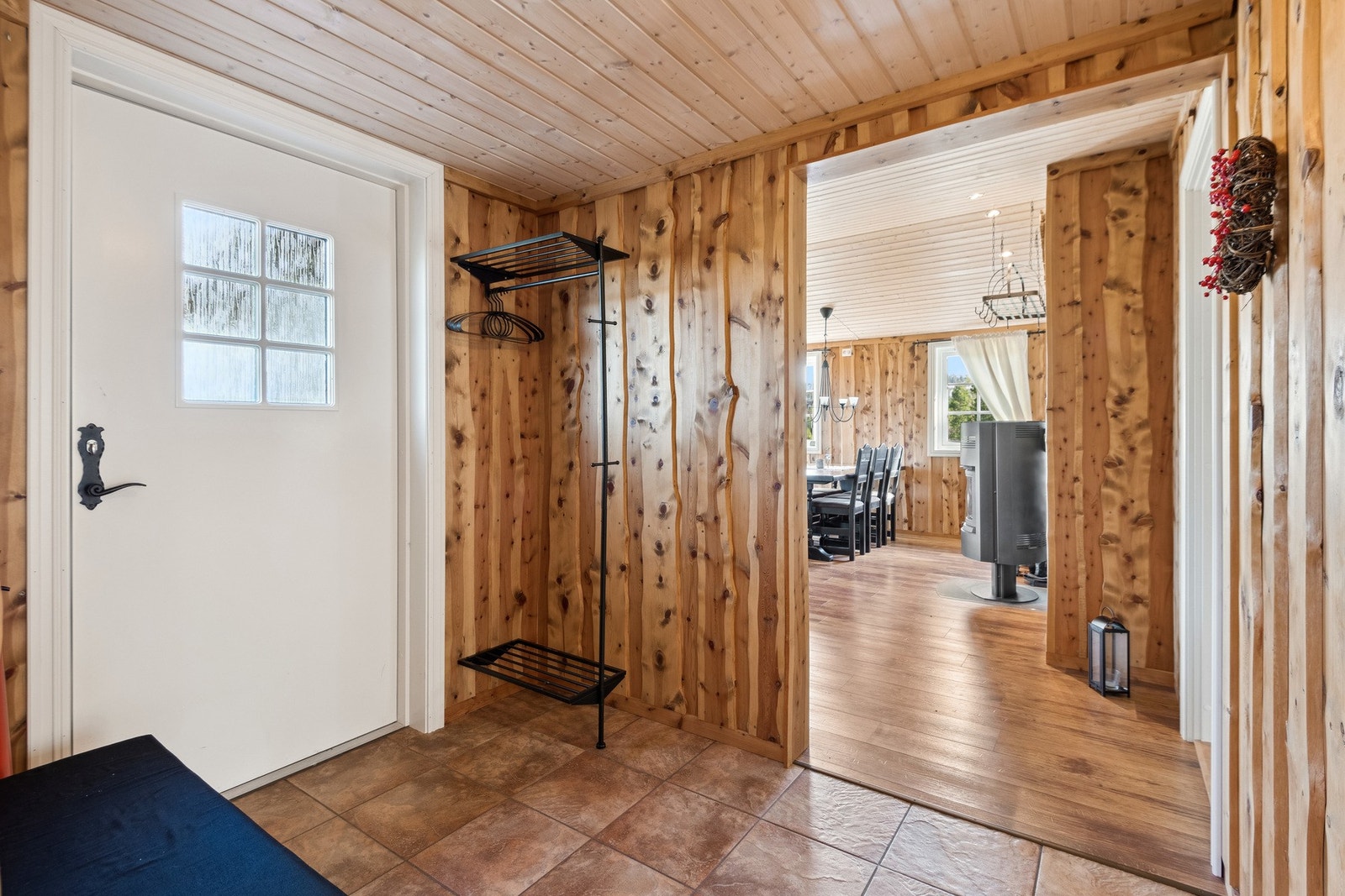 Flislagt gang med gulvvarme og plass til å henge fra seg klær og sko. Galleribilde