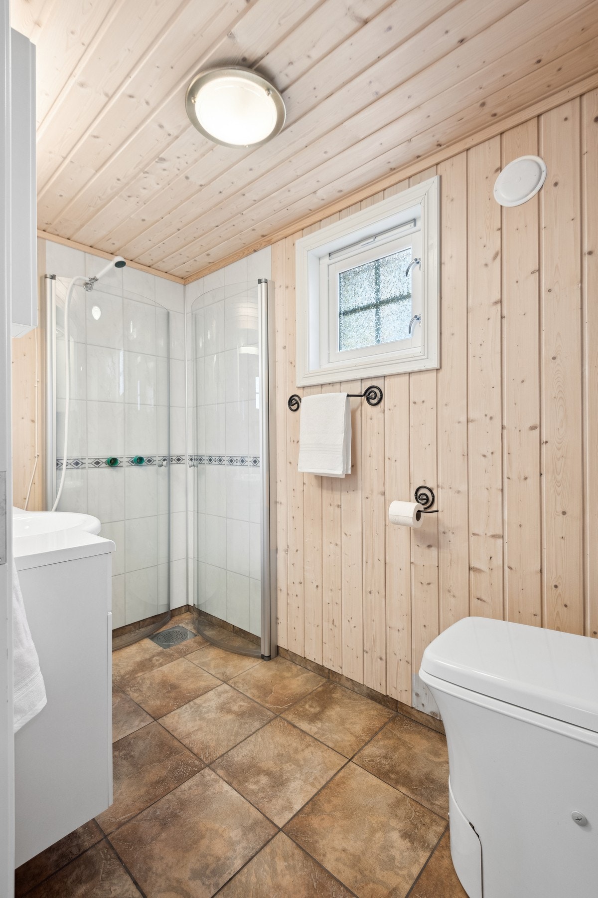 Flislagt bad med pumpedusj og forbrenningstoalett. Galleribilde