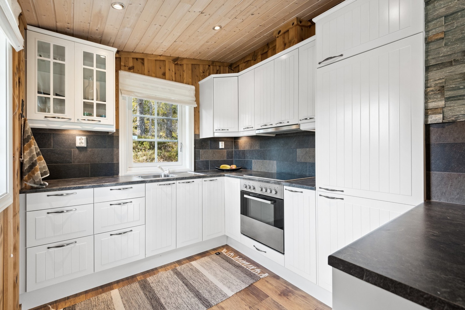 Lyst og innbydende kjøkken med mye skap og benkeplass. Galleribilde