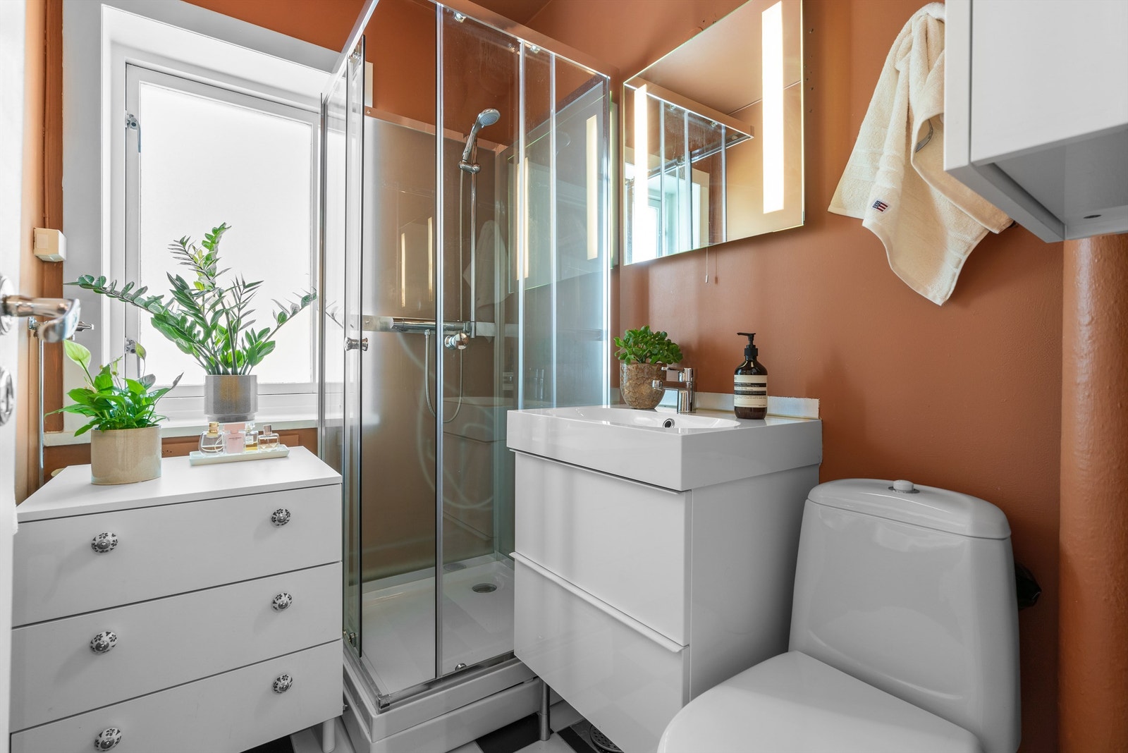 Badet er innredet med dusjkabinett, vegghengt skap med ovenpåliggende servant, speil med lys, samt toalett. Det er opplegg for vaskemaskin. Galleribilde
