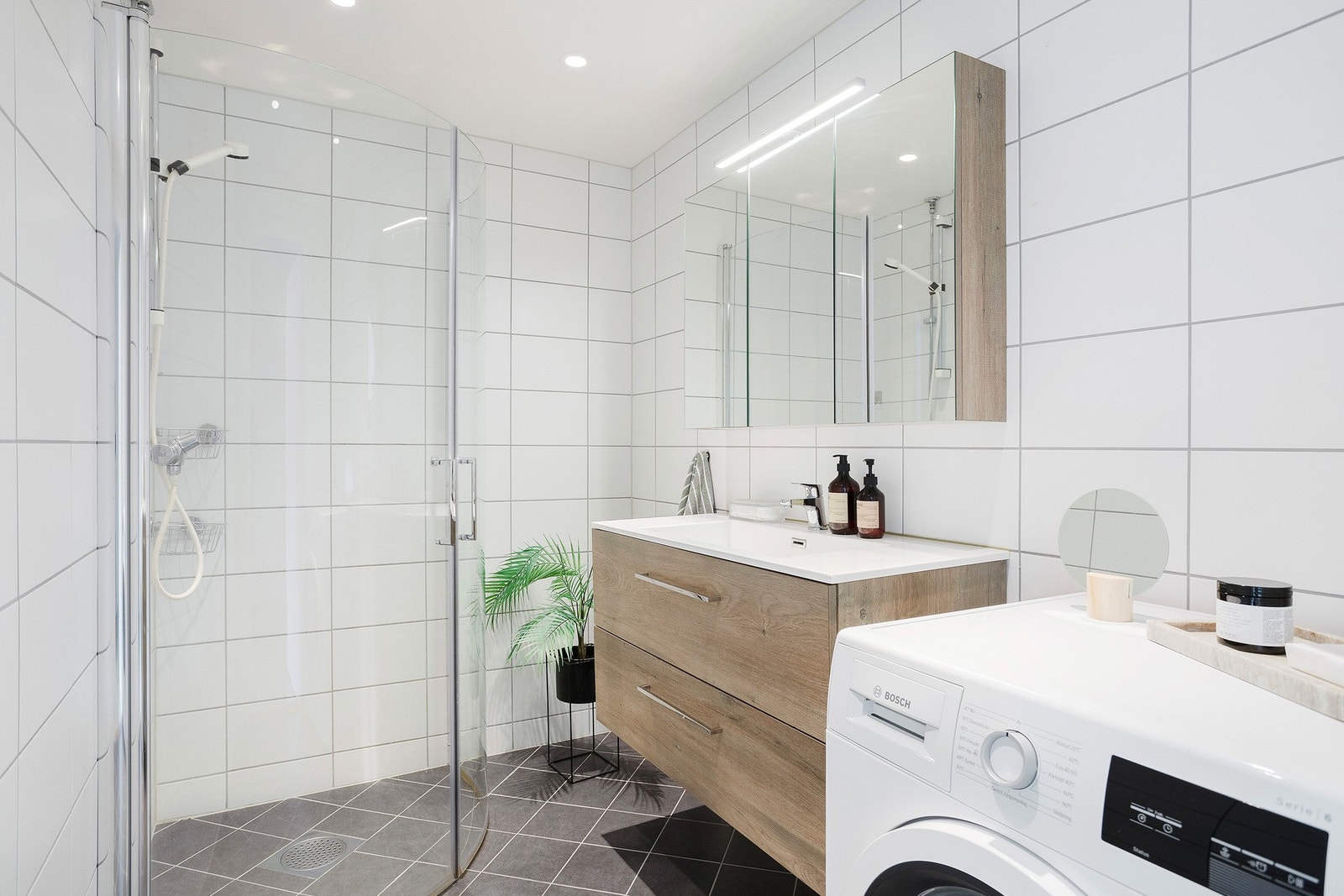 Lyst, flislagt baderom med gulvvarme og downlightsbelysning i taket. Badet ble pusset opp i regi av borettslaget i 2019 og fremstår moderne. Opplegg for vaskemaskin. Galleribilde