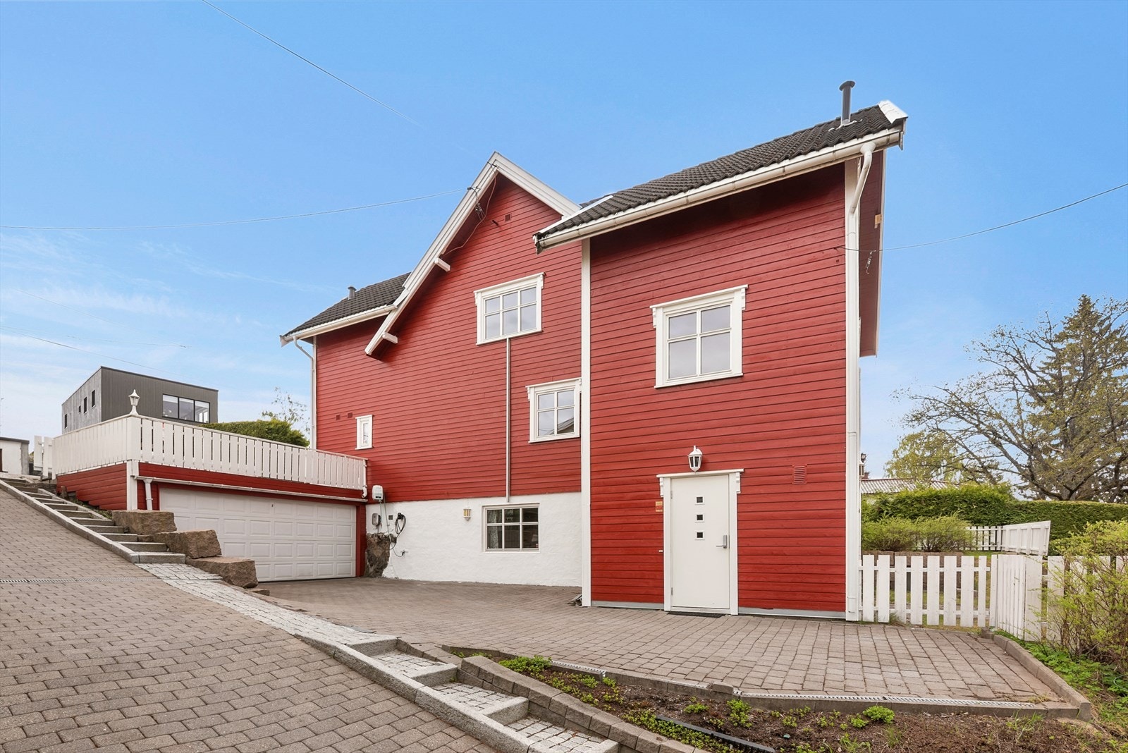 På nedsiden av huset befinner det seg en dobbelgarasje, samt eget inngangsparti til hybelen . Galleribilde