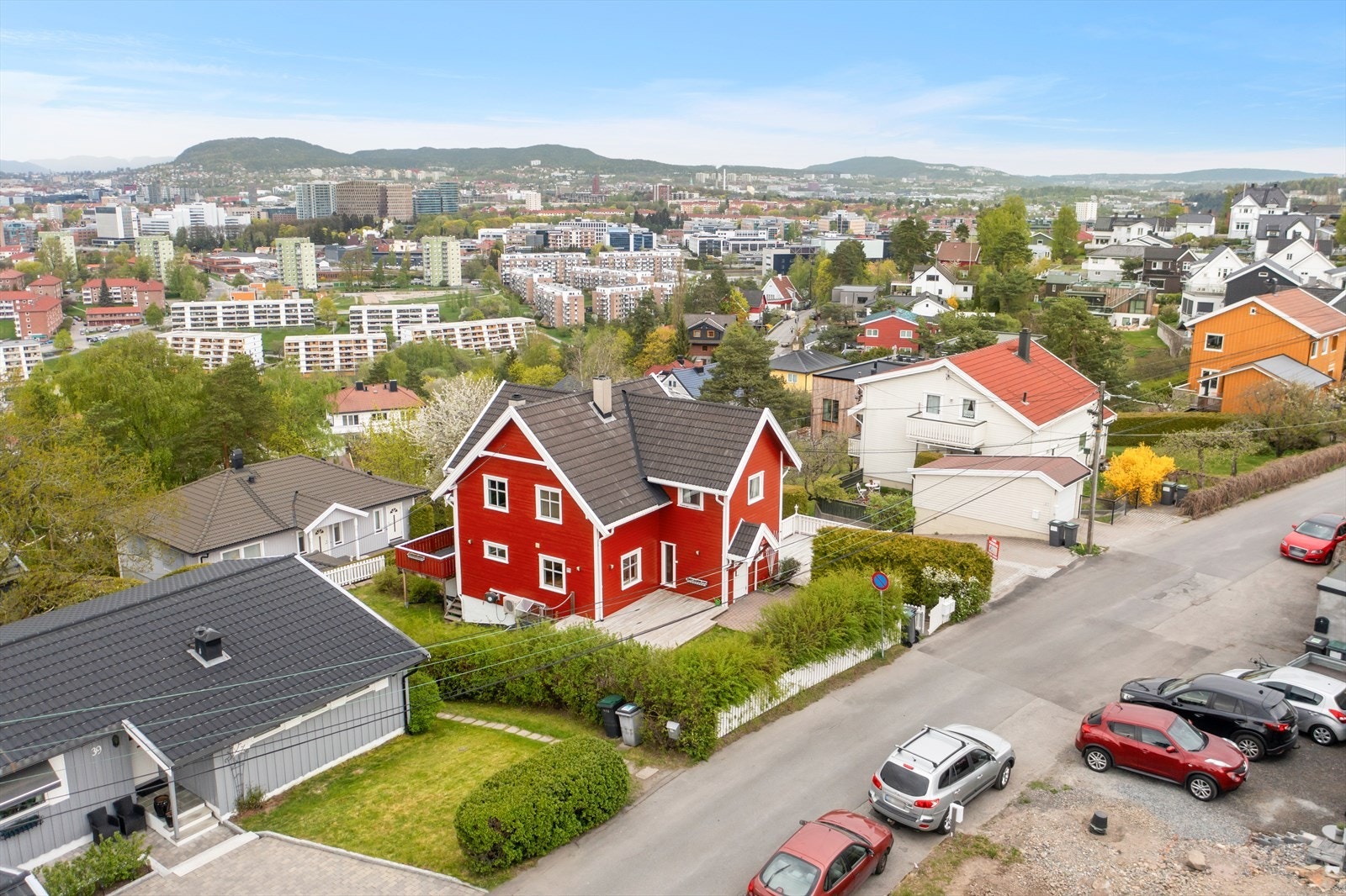 Boligen har pent opparbeidet tomt med plen og prydbusker. Galleribilde