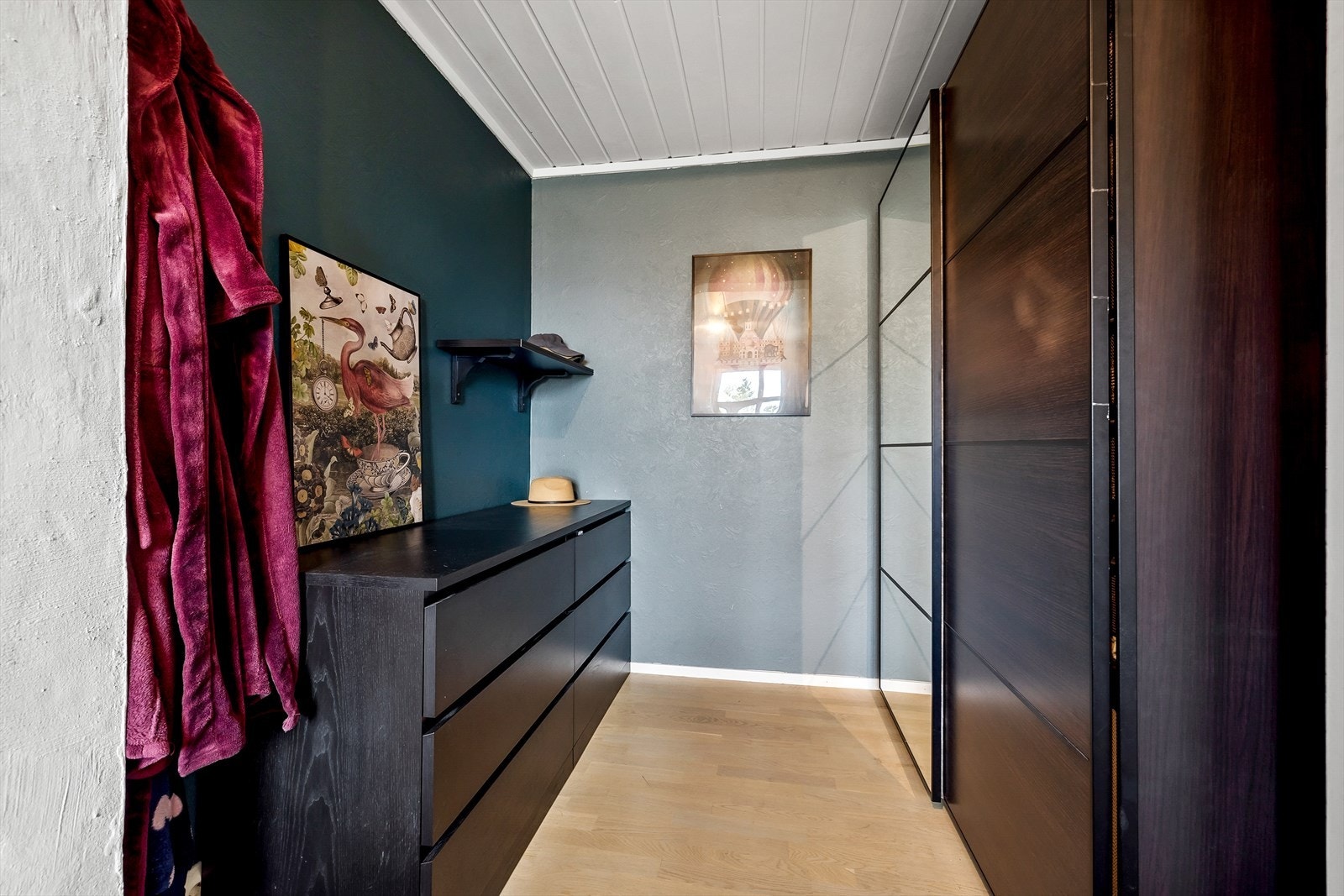 I tilknytning til sovealkoven er det et walk-in closet med rikelig skap- og oppbevaringsplass. Her innredet med en romslig garderobe samt en delikat kommode i liknende stil. Galleribilde