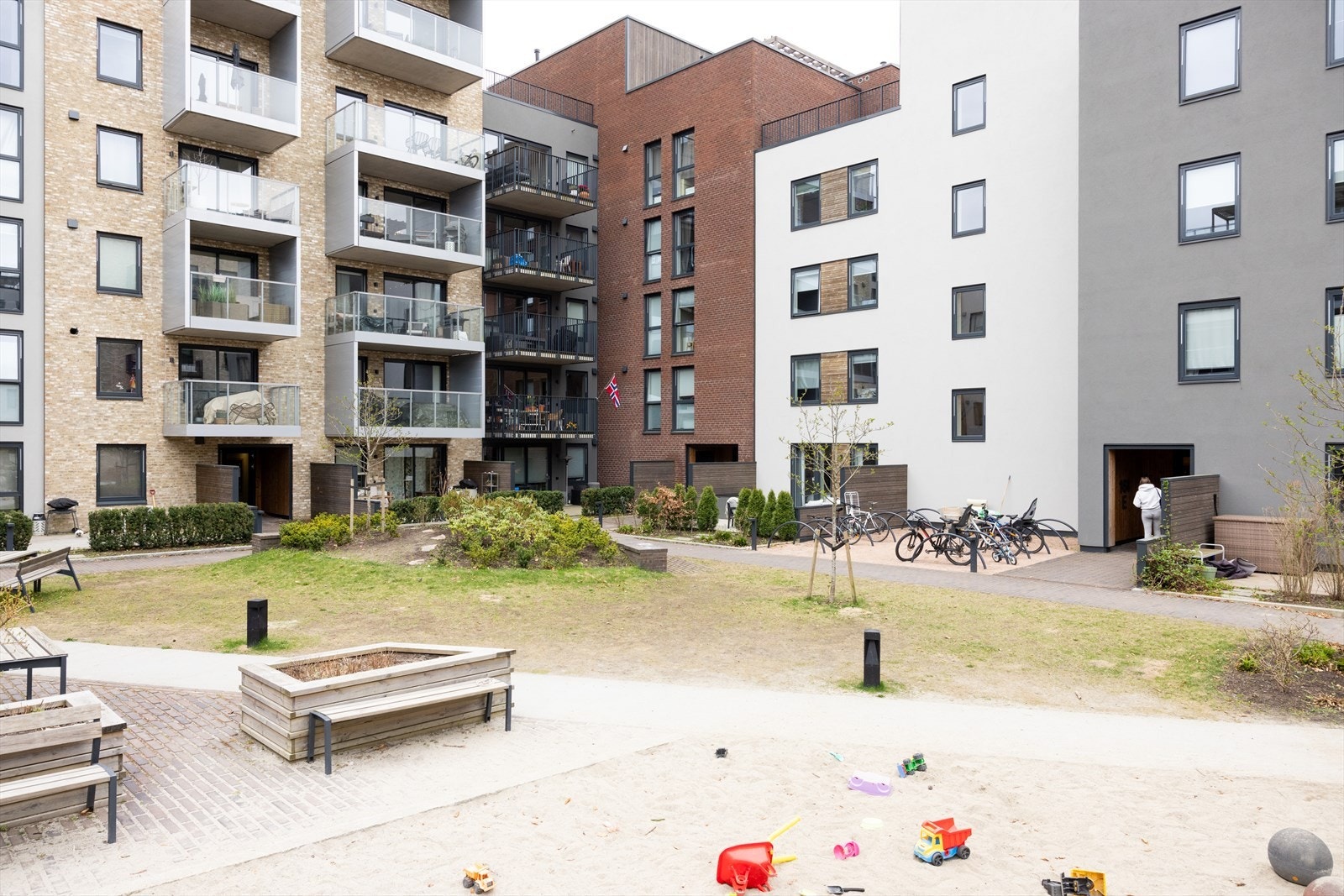 Meget koselig bakgård med lekstativer, beplantning og sittegrupper. Galleribilde