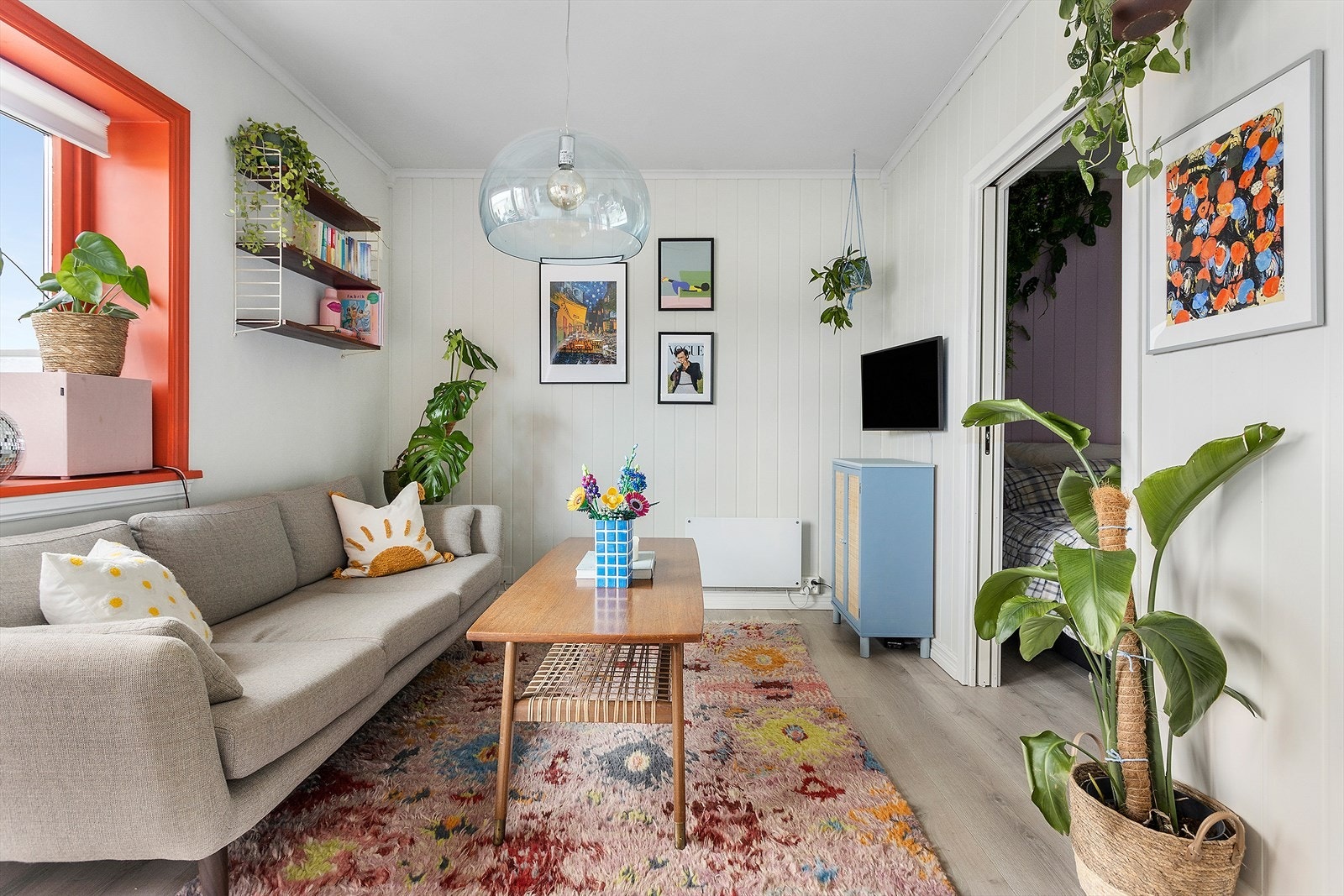 Stue har lysmalte panelvegger med laminat gulv. Galleribilde