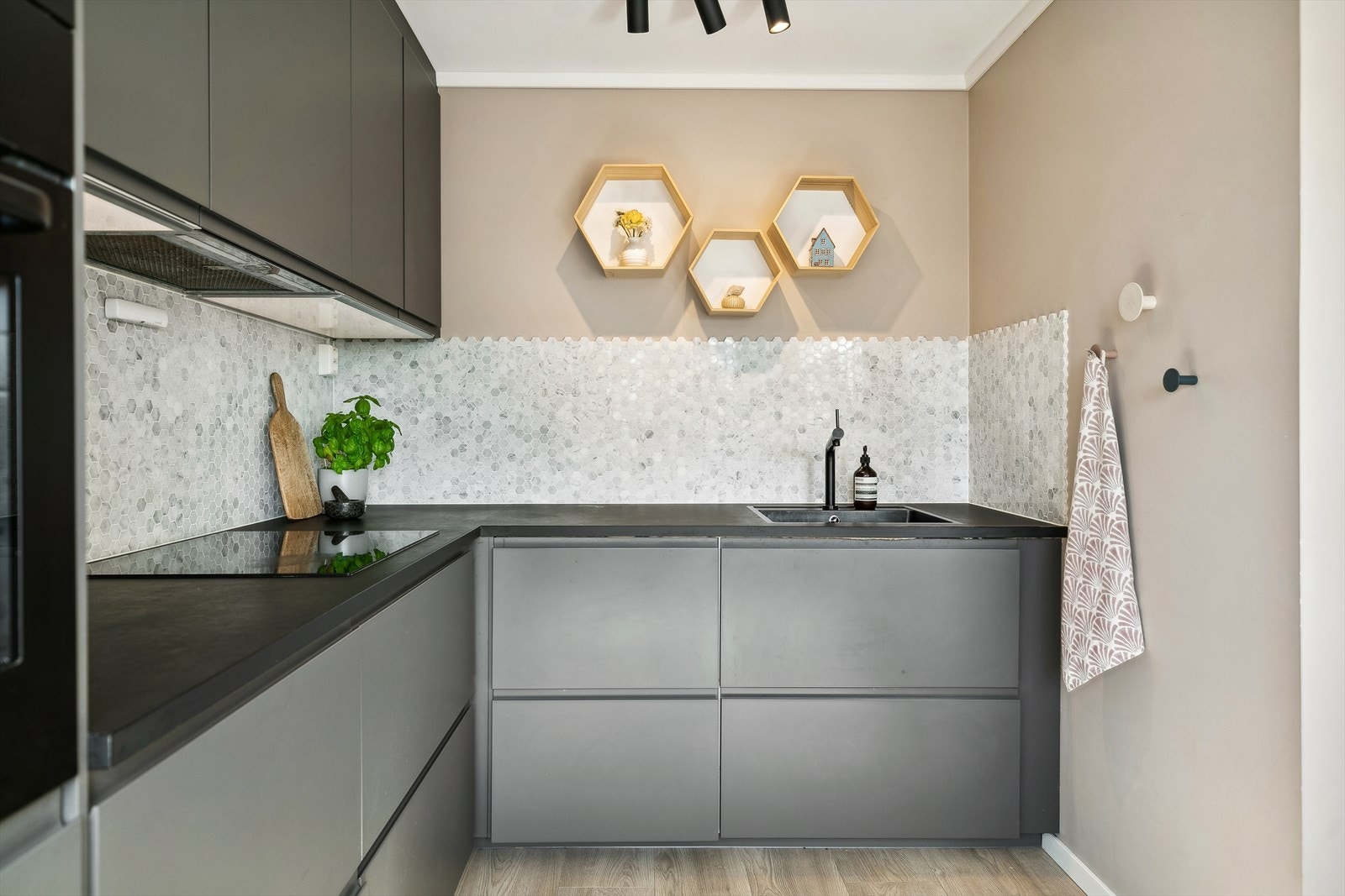 Mosaikk mellom kjøkkenbenken og overskap. Belysning under overskap. Galleribilde