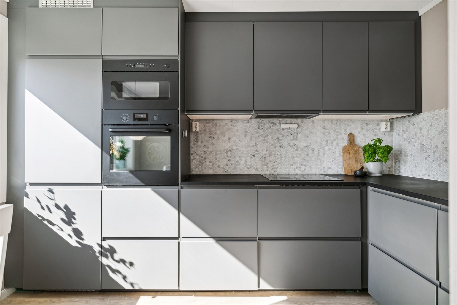 Hvitevarer bestående av induksjon koketopp, micro, stekeovn, kjøl/frys og oppvaskmaskin. Ventilator over kokesone. Galleribilde