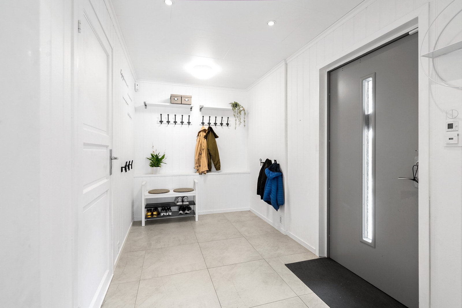 Lys og hyggelig flislagt inngang med god plass til å henge fra seg ytterklær Galleribilde