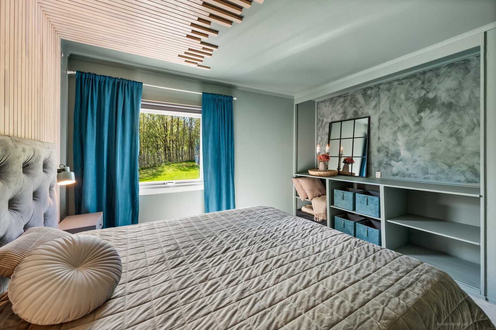 Hovedsoverommet er moderne innredet med spilevegg, tepper på gulv og hyller. Galleribilde