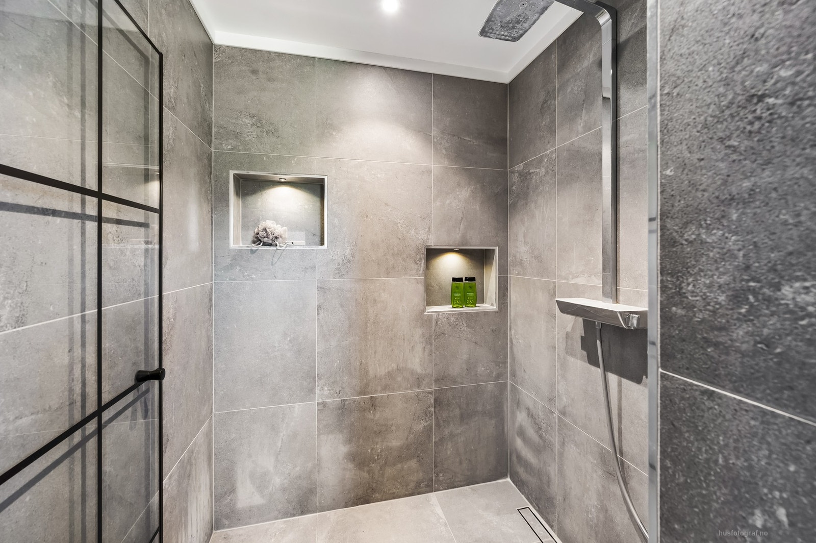 Badet har en stor dusjnisje med innfelte hyller og belysning. Galleribilde