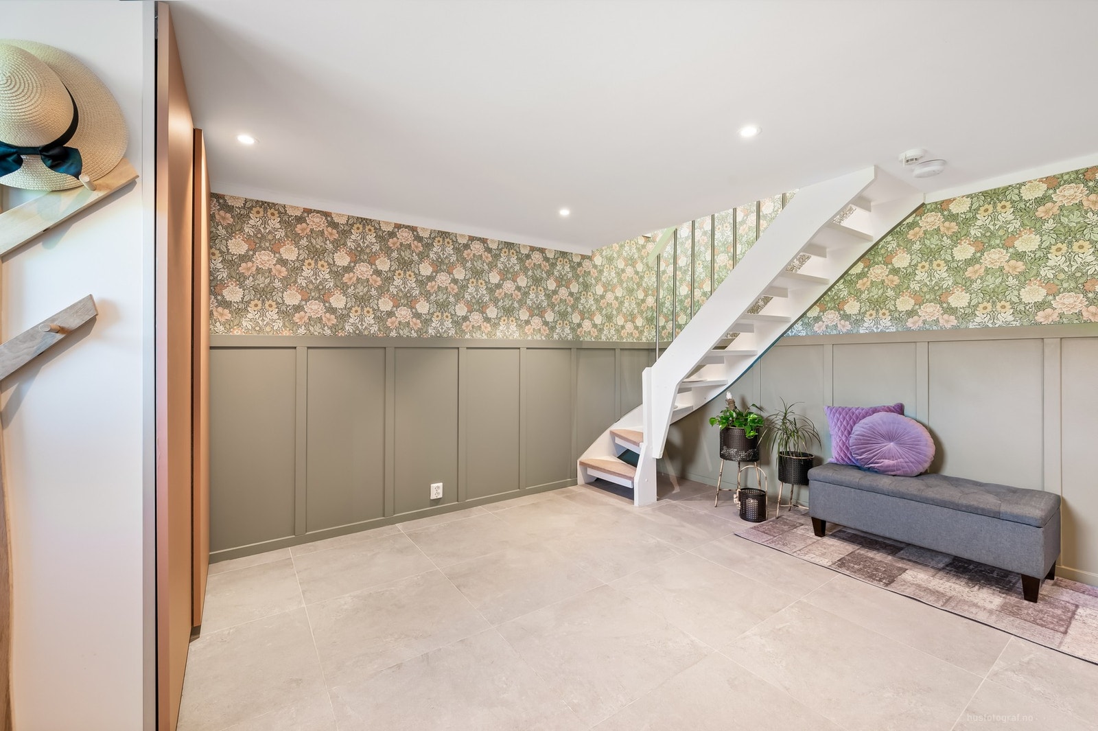 Boligen har en stor og innbydende entré/hall i underetasjen, med fliser på gulv, downlights i himling og garderobeskap. Galleribilde