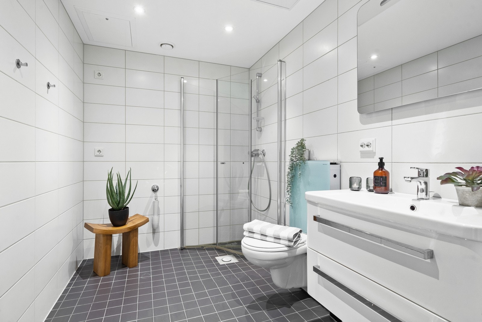 Stort og fullverdig bad med hvit moderne baderomsinnredning. Opplegg for vaskemaskin. Downlights i tak, og gulvvarme på badet. Galleribilde