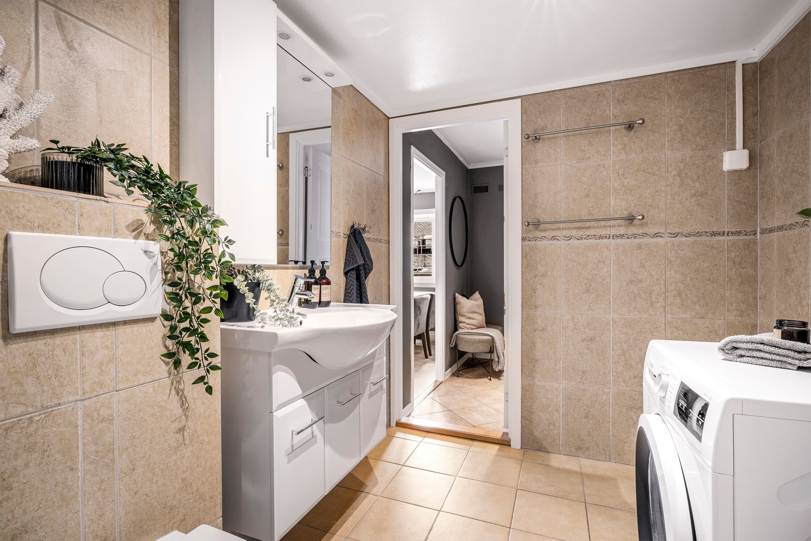 Badet er utstyrt med baderomsmøbel, vegghengt toalett, dusjhjørne og opplegg for vaskemaskin. Galleribilde