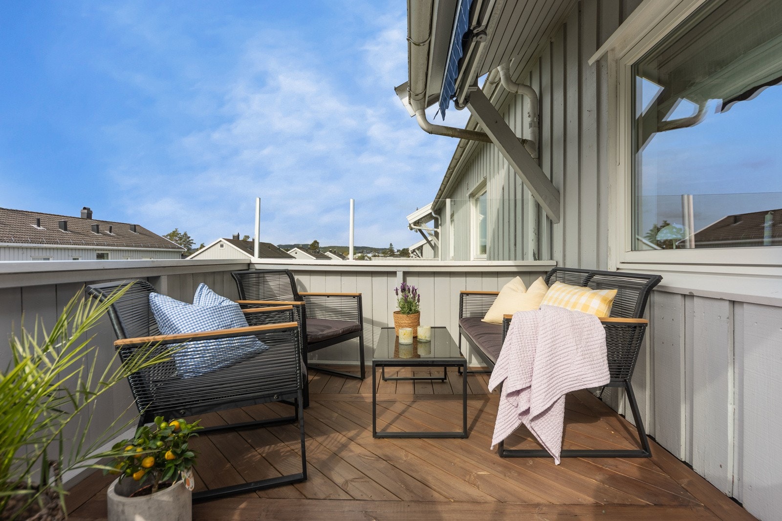 Balkongen har nyere dekke i tre, tett rekkverk og blå markise. Her er solforholdene gode, og det er fin, langstrakt utsikt. Galleribilde