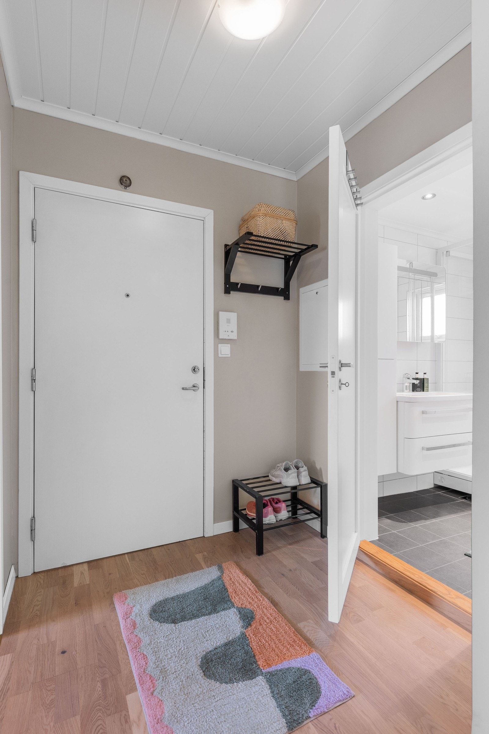 Leiligheten har en pen entré med lysegrå vegger og trestavs parkettgulv. Velkommen inn! Galleribilde