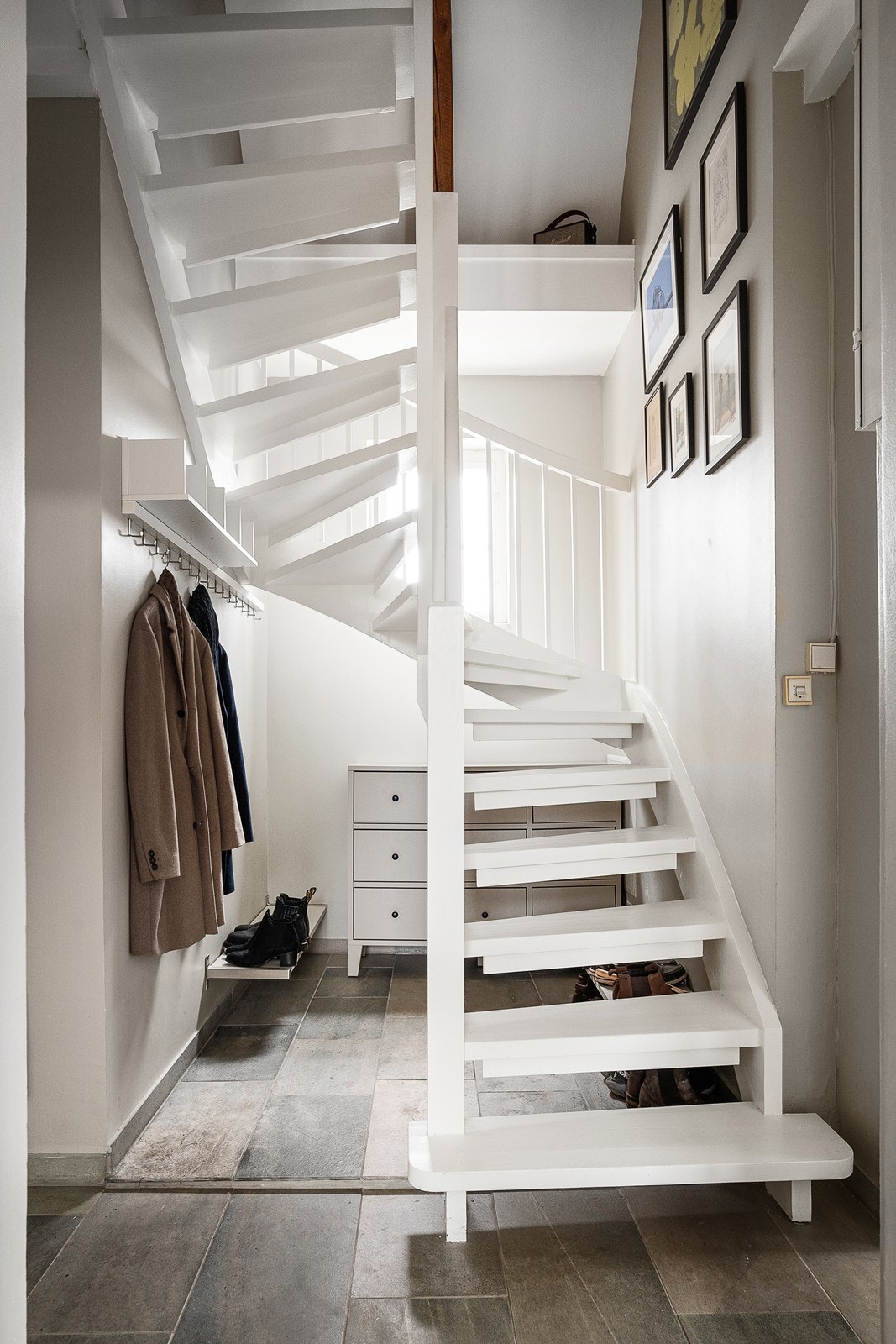 Fra entréen kommer man opp til boligens loftsetasje. Det er gode lagringsmuligheter under trappen. Galleribilde