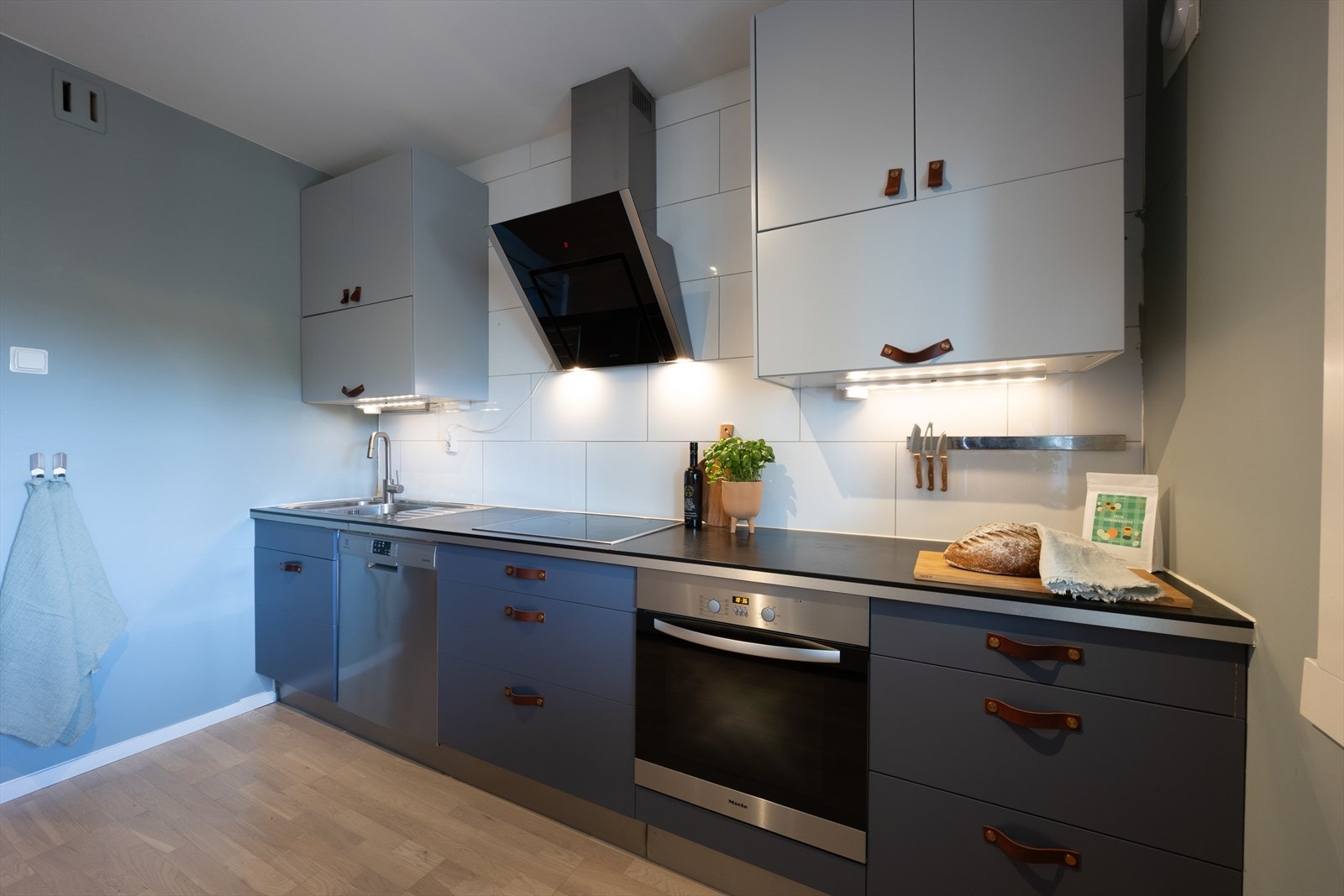 Kjøkkeninnredning med glatte fronter, laminat benkeplate og fliser på vegg. Galleribilde