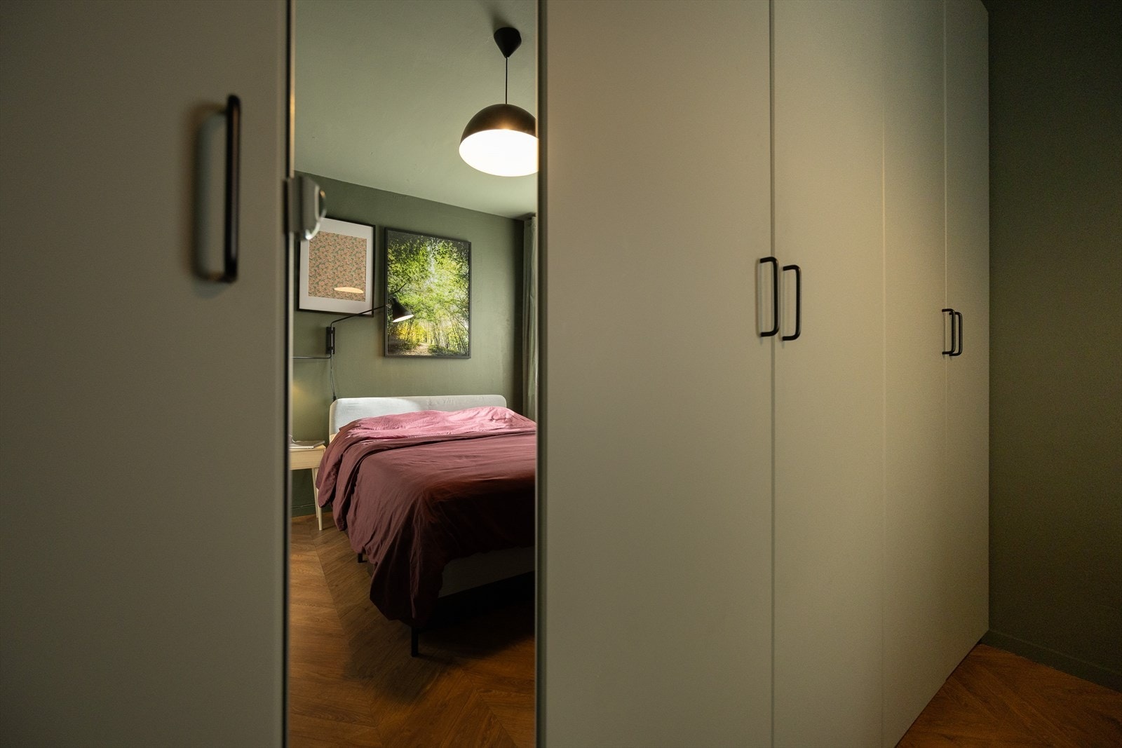 Romslig garderobeskap med matchende grønnfarge til tak som gir et helhetlig og lunt uttrykk. Galleribilde