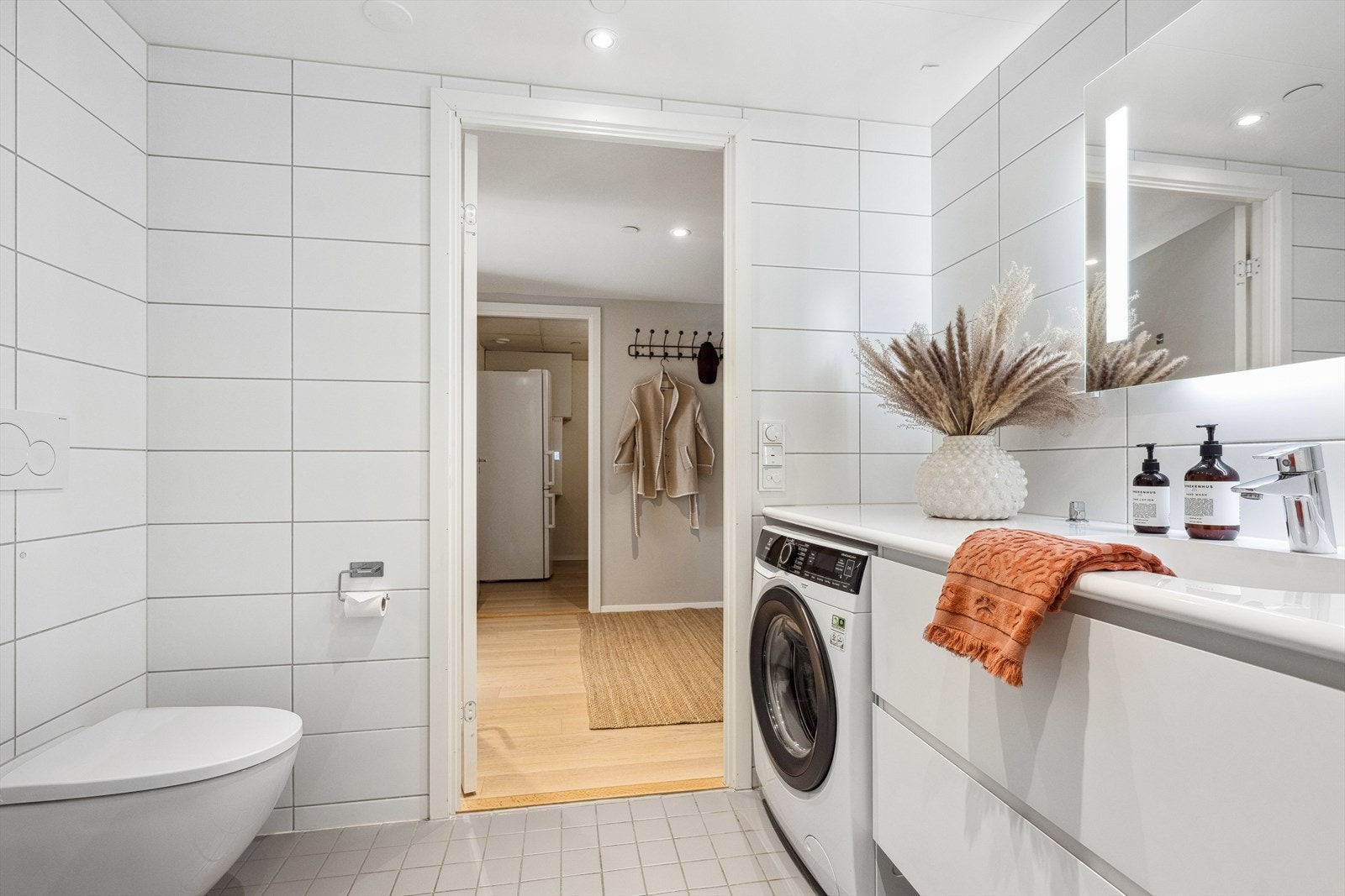 Flott baderom med opplegg for vaskemaskin, wc, dusj og pen skapinnredning. Galleribilde