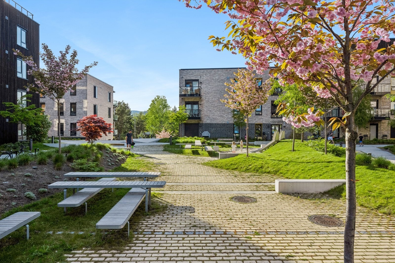 Sameiets fellesareal med sittegrupper, lekeplass og gode solforhold Galleribilde