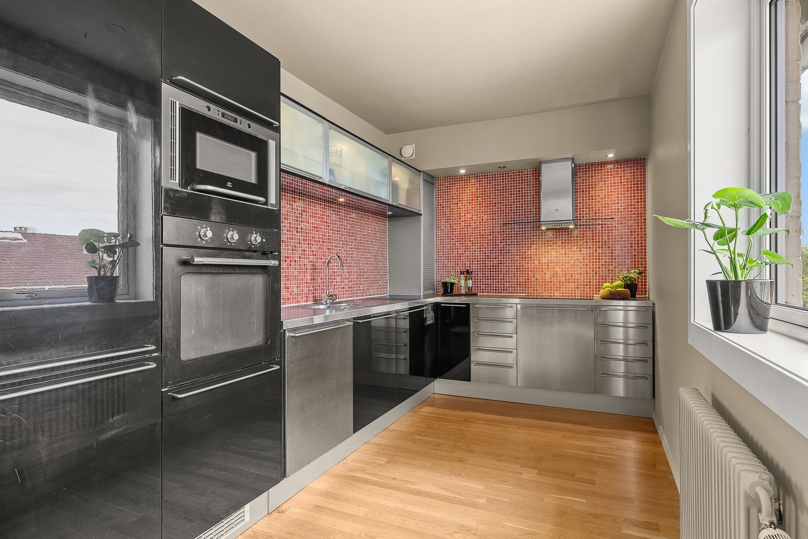 Et velutstyrt kjøkken fra 2003 med fronter i sort høyglans og rustfritt stål, samt overskap med vitrinedører. God skap- og benkeplass som har nok av tumleplass for de mest aktive hobbykokker, og som fremstår som meget funksjonelt Galleribilde