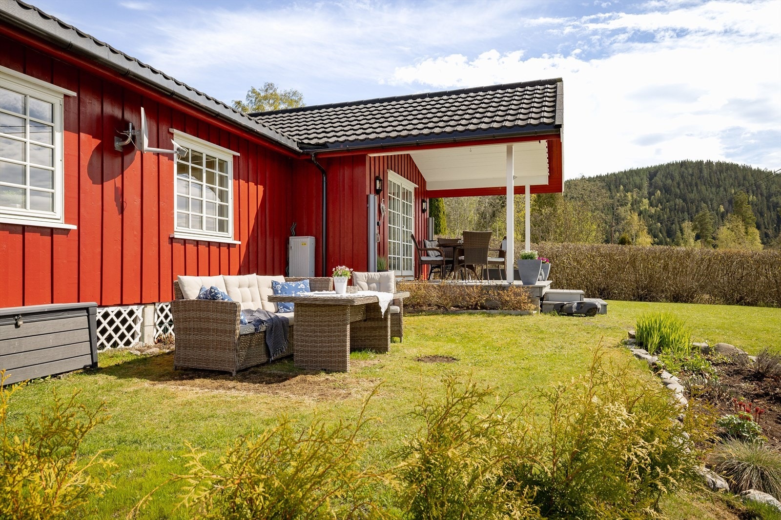 Tomta og hagen er velholdt og består av blomsterbed, frukttrær og diverse prydvekster. Det er god plass til flere sittegrupper. Galleribilde