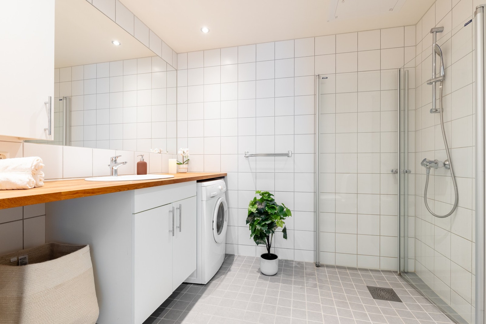 Boligens baderom er lyst, flislagt og har varme i gulv samt downlights i himling. Praktisk nisje for plassering av vaskemaskin og tørketrommel. Galleribilde