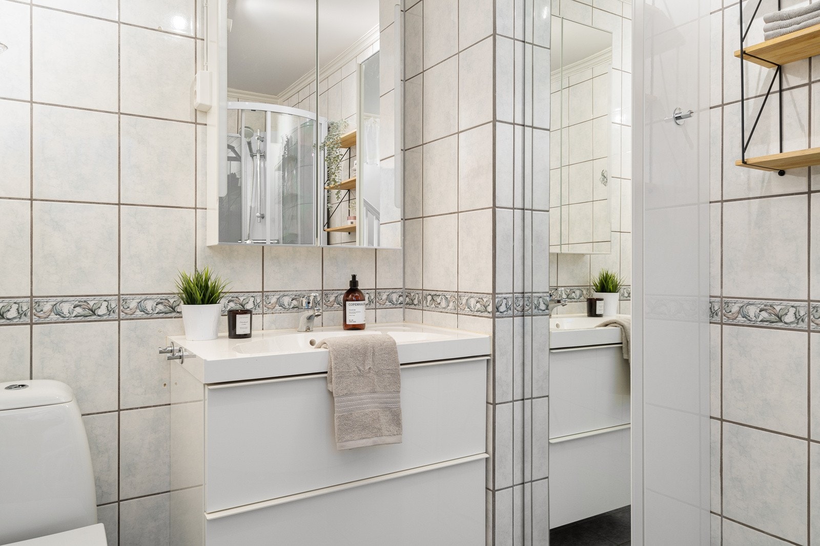 Badet er utstyrt med gulvstående toalett, dusjkabinett og baderomsinnredning. Galleribilde