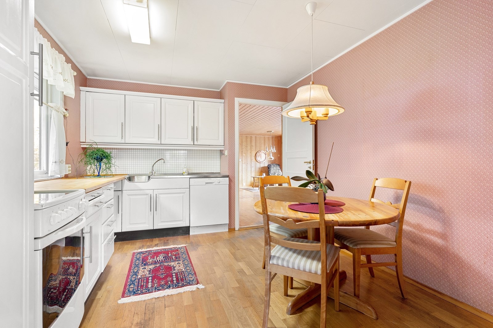 Kjøkkeninnredningen har malte, profilerte fronter og benkeplate i heltre. Galleribilde