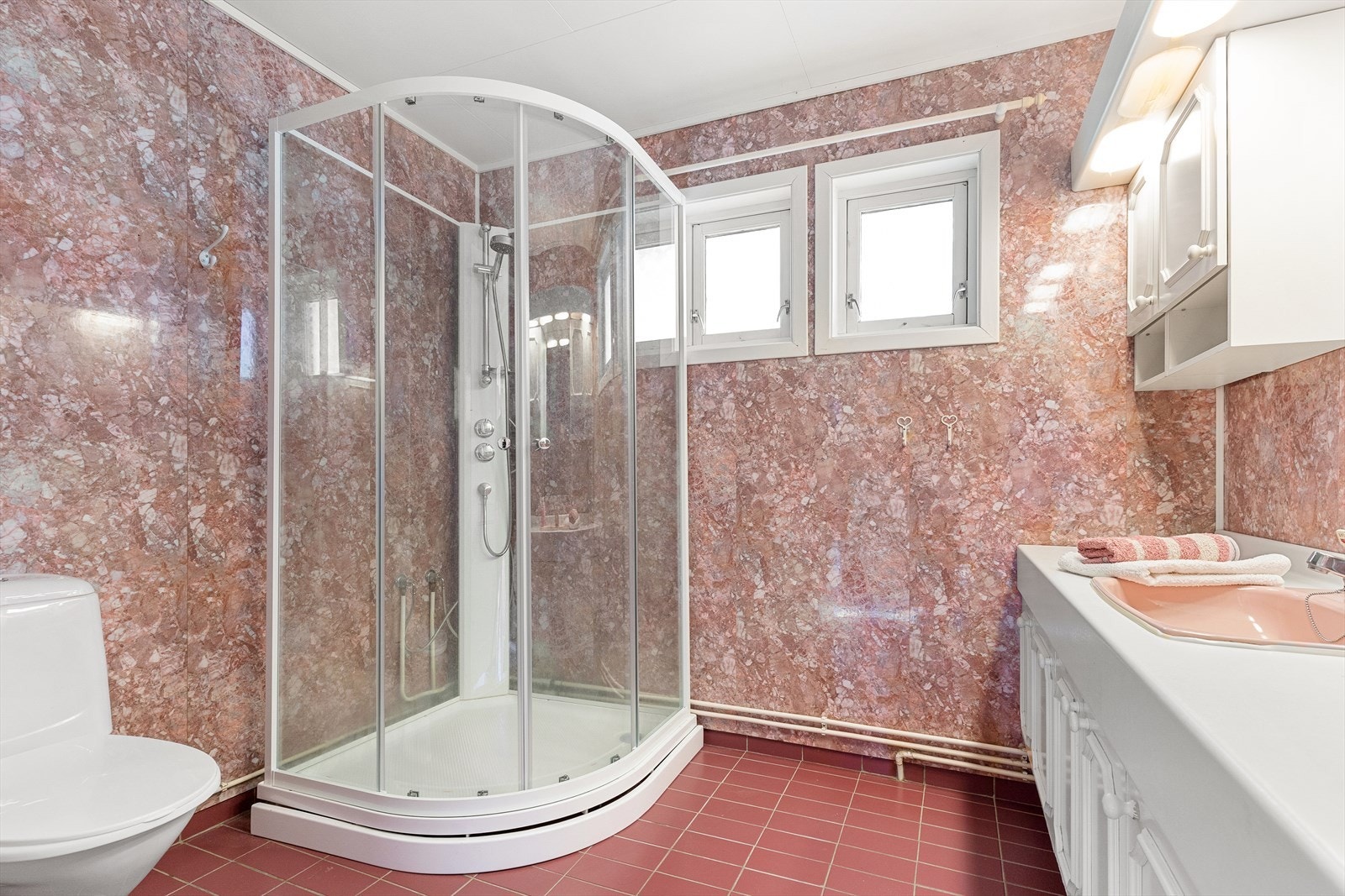 Badet i 1.etasje inneholder innredning med servant, toalett og dusjkabinett. Galleribilde