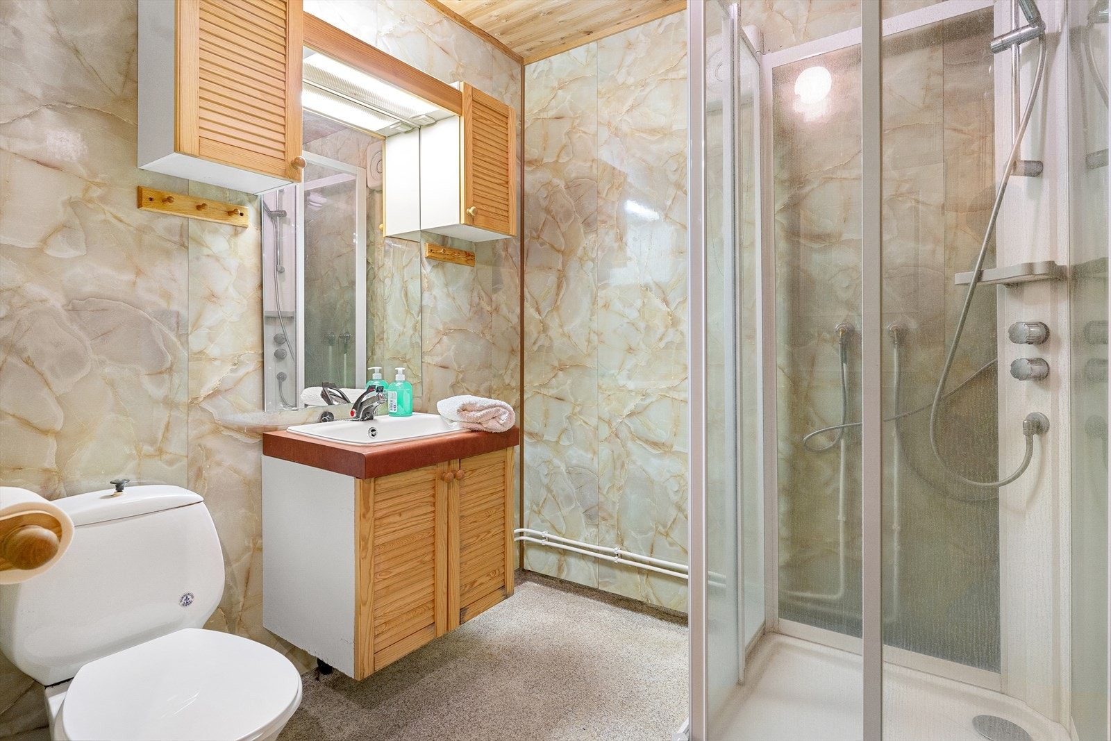 Badet i underetasjen inneholder innredning med servant, toalett og dusjkabinett. Det er elektrisk varme i gulvet. Galleribilde