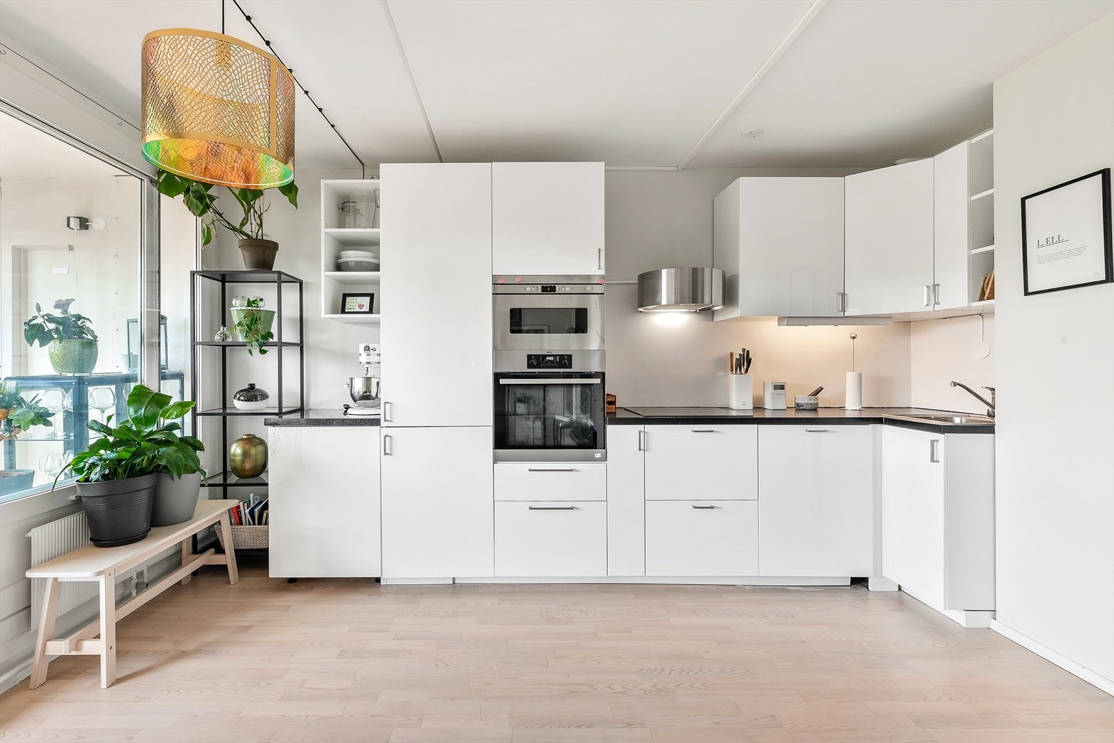 Kjøkkenet har en pen innredning med hvite og glatte fronter. Benkeplaten er av laminat med nedfelt kum i rustfritt stål. Stekeovn, platetopp, kjøl/frys, micro og oppvaskmaskin er integrert i innredningen. Galleribilde