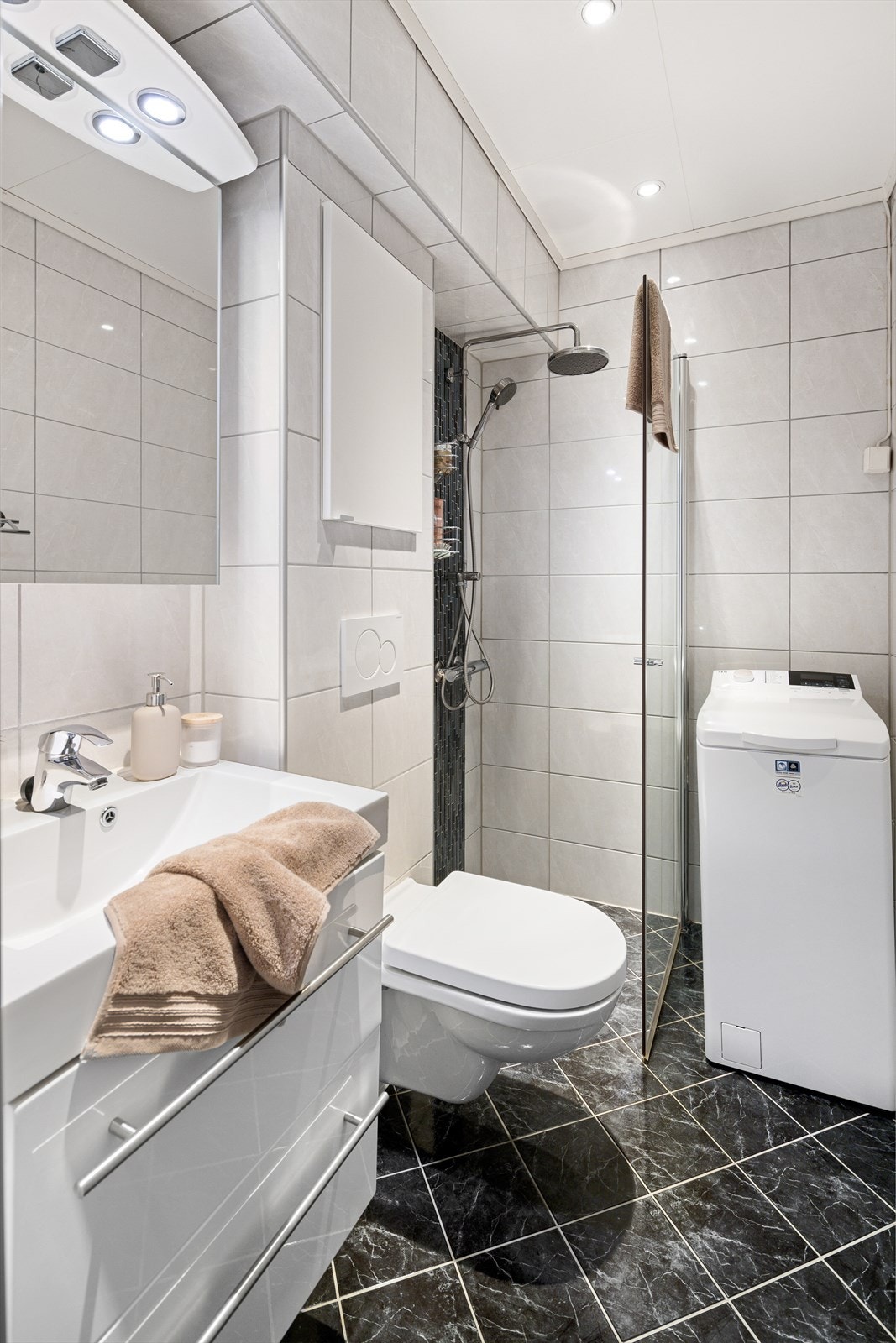 Badet har flislagte overflater, med varmekabler i gulvet og innfelte downlights i himlingen. Galleribilde