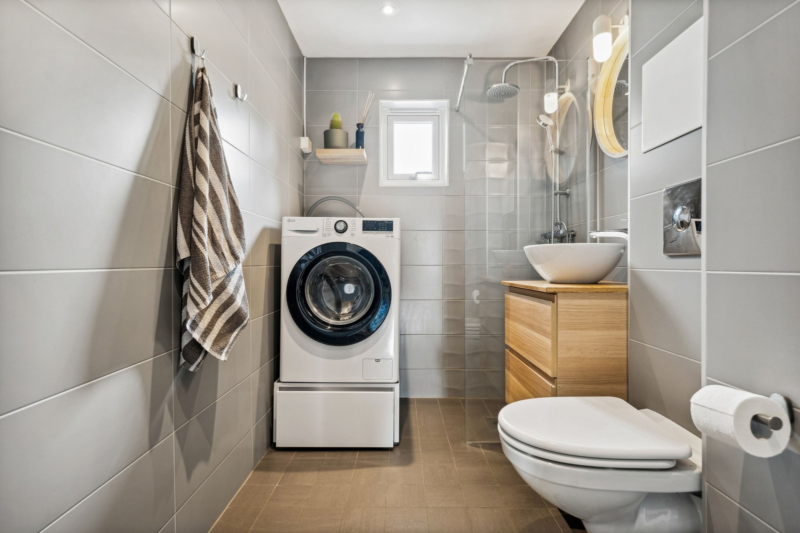 Lekker flislagt baderom med opplegg for vaskemaskin. Galleribilde