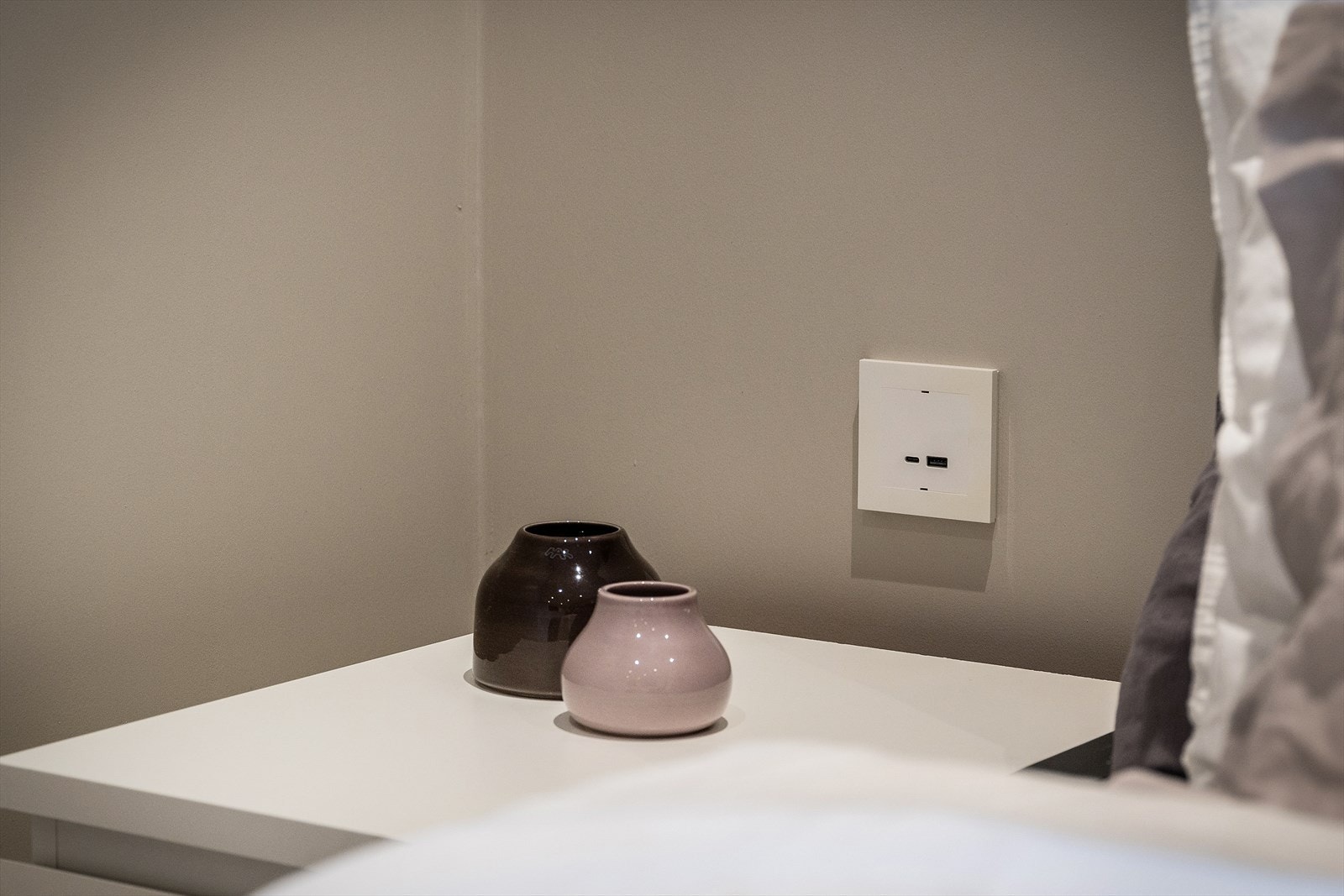 Uttak for lader på begge sider av sengen på soverommet. Galleribilde