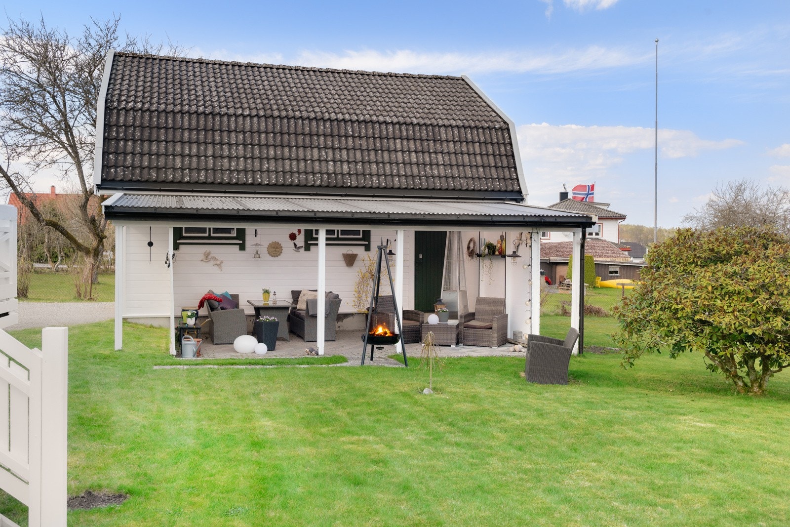 På gresset kan barna leke fritt og de voksne følge med fra denne fine overbygde terrassen. Galleribilde