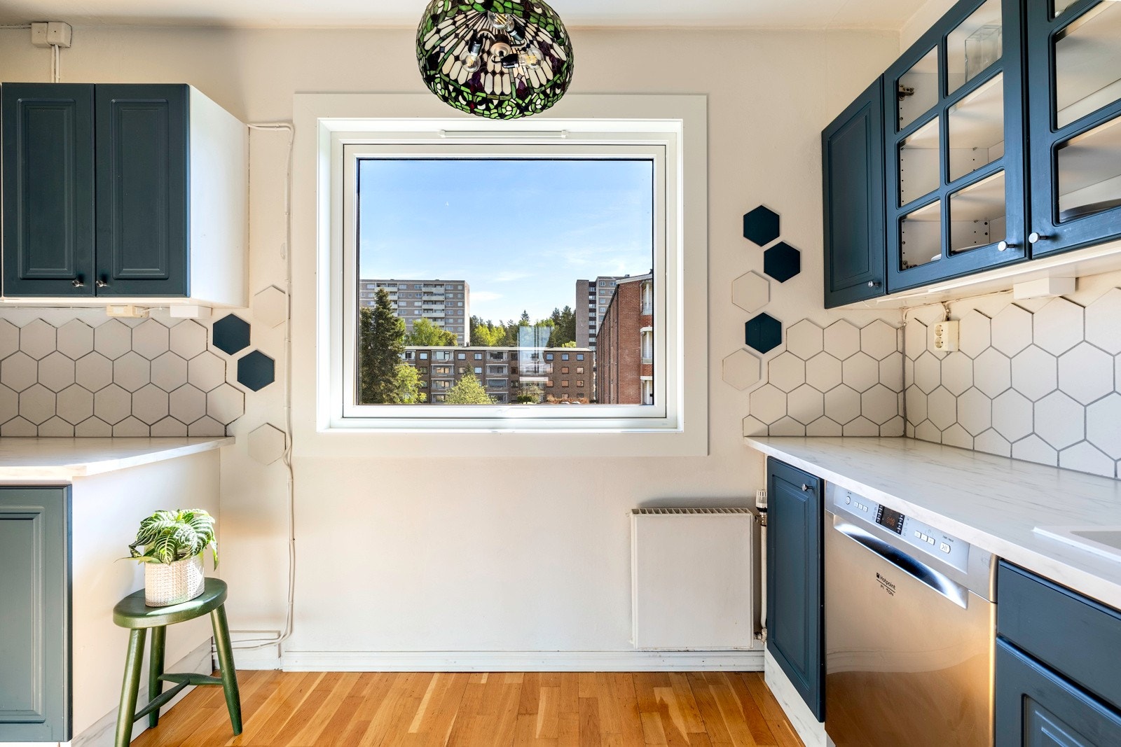 Kjøkkeninnredningen er fordelt på to sider av rommet og har blåmalte profilerte fronter og vitrineskap. Galleribilde