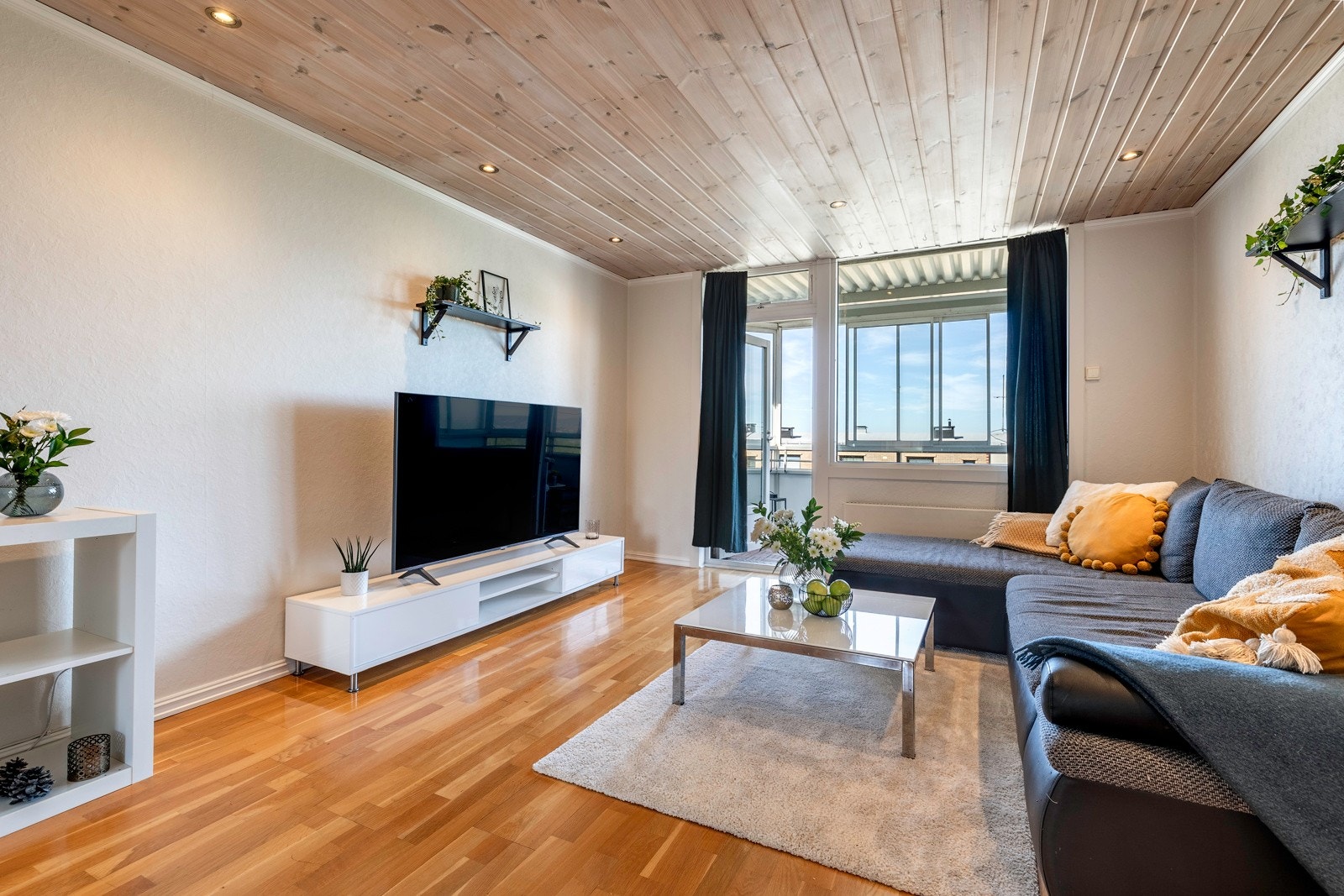 Stuen er tilknyttet soverom og kjøkken og er ellers forholdsvis likt innredet som entreen med parkett på gulvet, lysmalte vegger og hvitlasert panel i himlingen med downlights i kant. Galleribilde