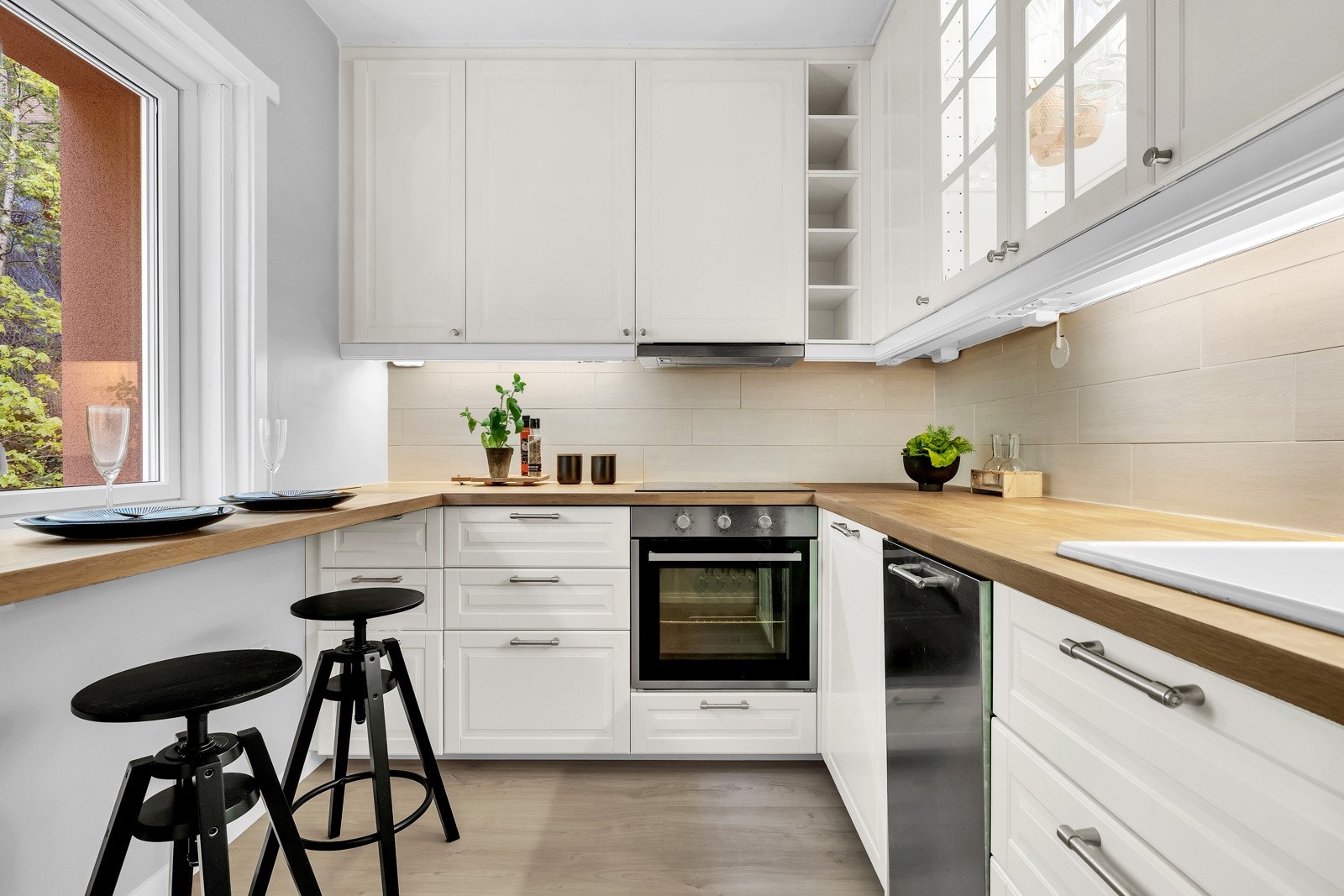 Pent utført med skap helt opp til taket og hvite, profilerte fronter og heltre benkeplate. Galleribilde