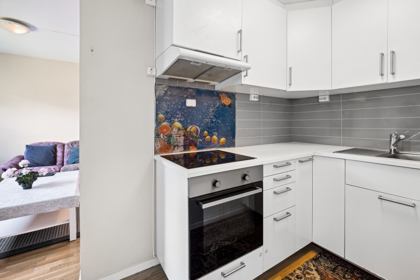 Innredning med laminerte skrog, glatte fronter, laminat over benkeplate, kjøkkenkum og vifte på vegg. Galleribilde