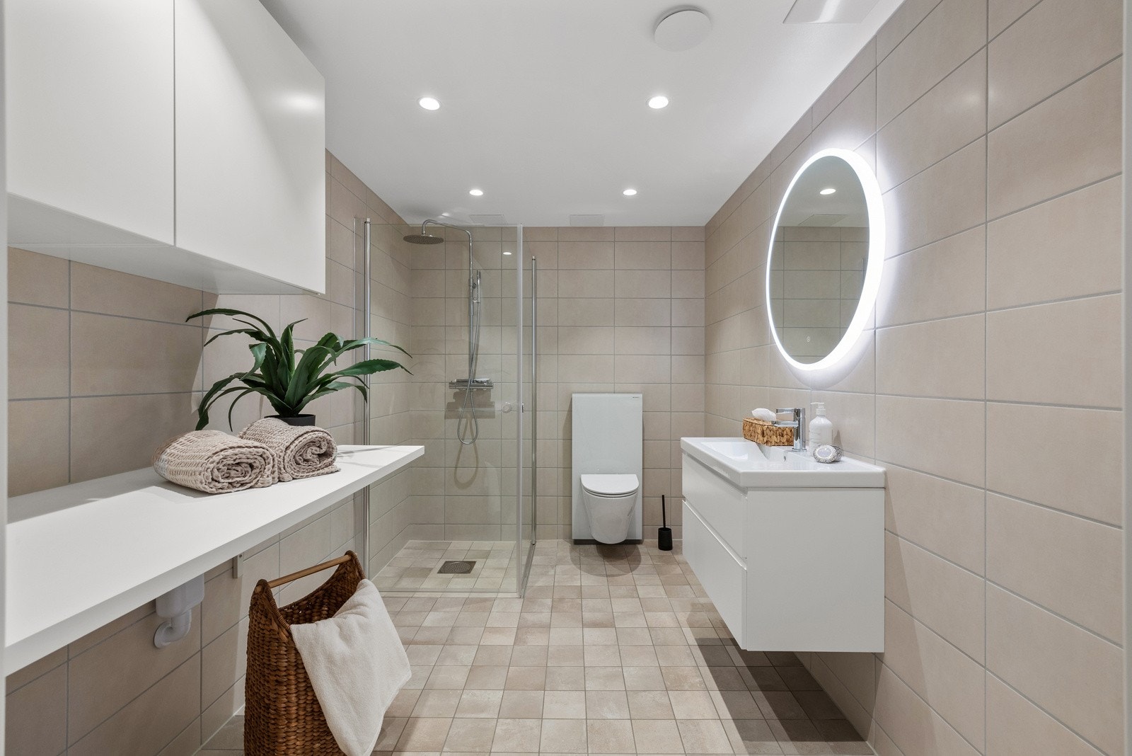 Badet er innredet med dusjnisje med regfallsdusj, servant med skuffeseksjon, klosett og overskap med benk for plass til vaskemaskin og tørketrommel. Galleribilde